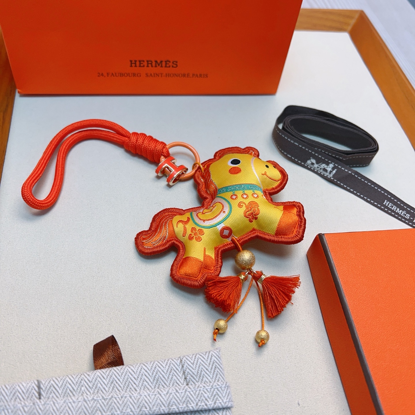 Hermes Year of the Horse Charm Keychain pendant Orange enamel H hardware yellow fabric horse charm with orange embroidery orange cord strap gold tone metal beads orange tassels 12cm strap length