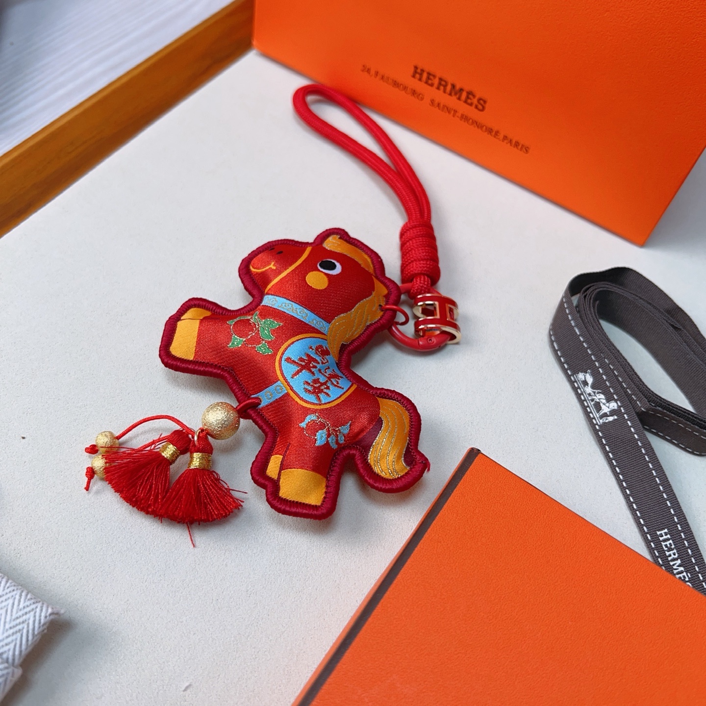 Hermes Year of the Horse Lucky Tassel Charm pendant Red fabric with gold blue green decorative details red cord strap gold-tone metal hardware red tassels 12cm total length
