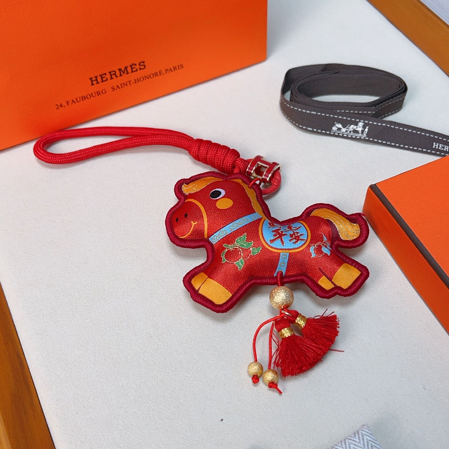 Hermes Year of the Horse Lucky Tassel Charm pendant Red fabric with gold blue green decorative details red cord strap gold-tone metal hardware red tassels 12cm total length