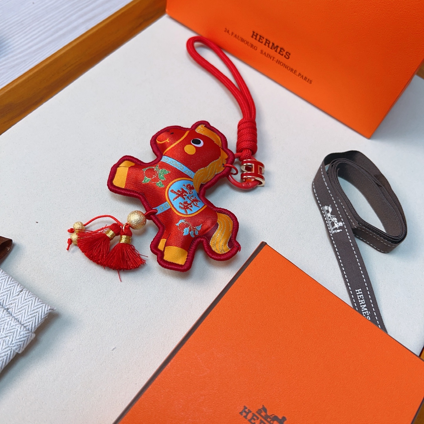 Ciondolo Hermes Anno del cavallo Lucky Nappa Tessuto rosso con dettagli decorativi oro blu verde cinturino in cordino rosso hardware in metallo color oro nappe rosse lunghezza totale 12 cm
