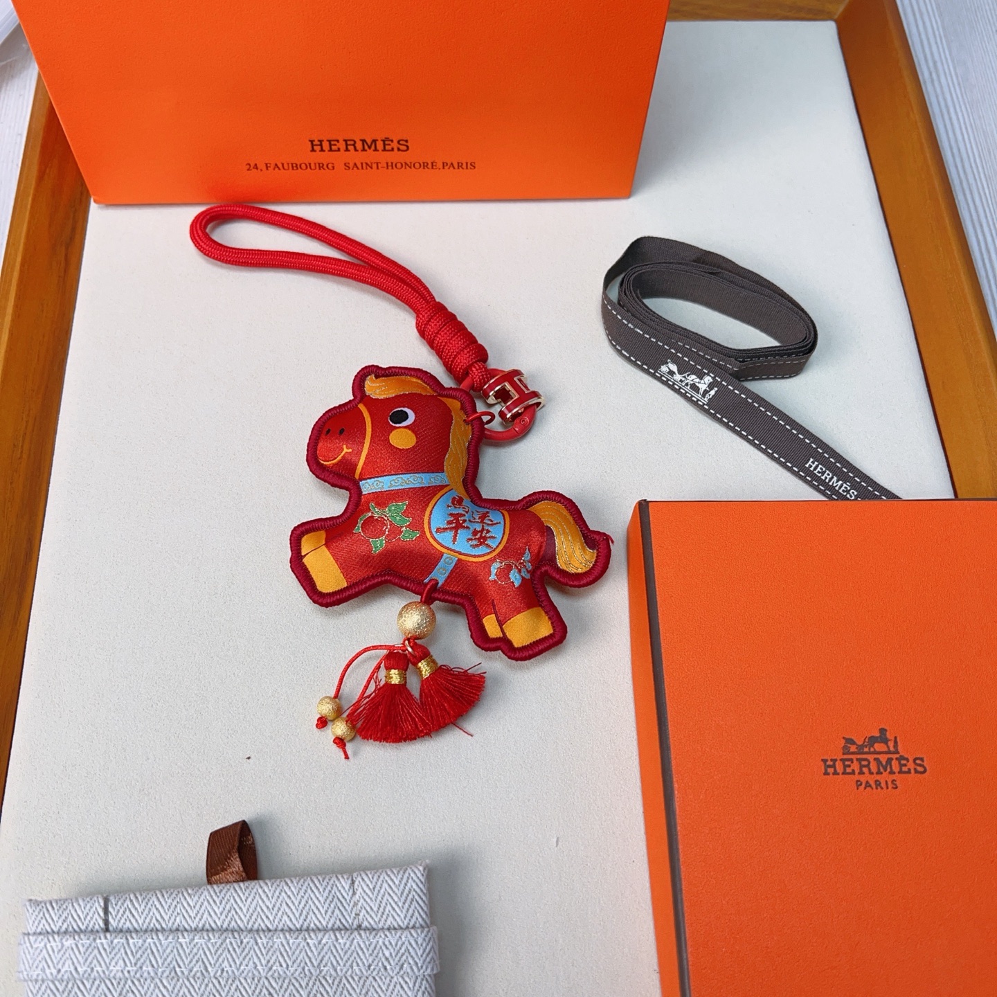 Hermes Year of the Horse Lucky Tassel Charm pendant Red fabric with gold blue green decorative details red cord strap gold-tone metal hardware red tassels 12cm total length