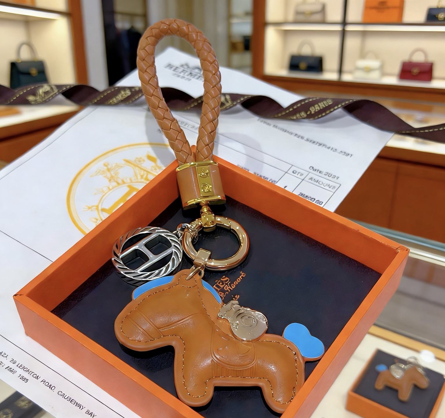 Pendentif Hermes Rodeo Braided Strap Key Charm Cuir marron doré avec des accents bleu ciel Quincaillerie en métal doré et argenté Longueur totale de 12 cm