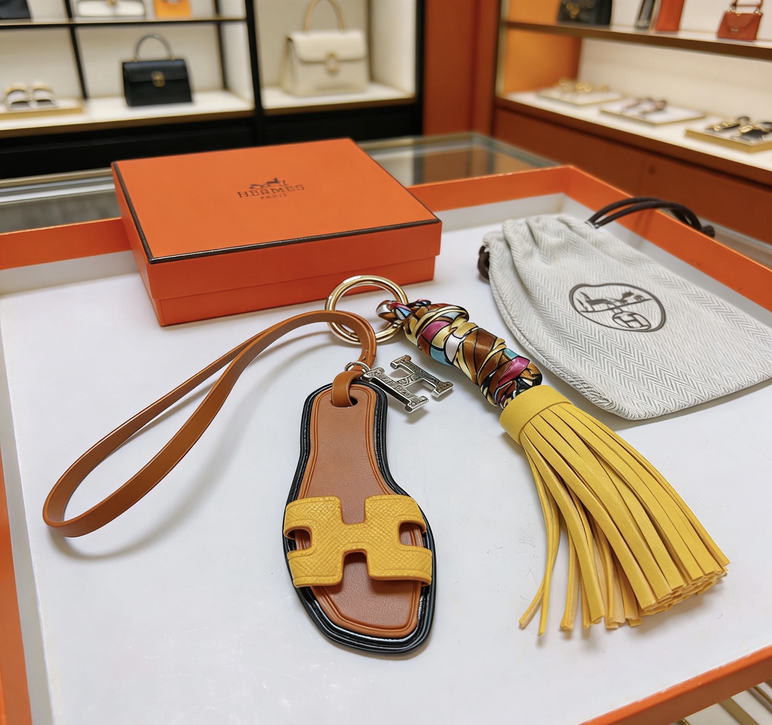 Hermes Oran Sandalo Borsa con nappa Fascino Portachiavi Ciondolo Metallo color oro Pelle marrone Pelle gialla Seta multicolore Ciondolo H color argento Bordo nero Rifinitura 15 cm Lunghezza totale