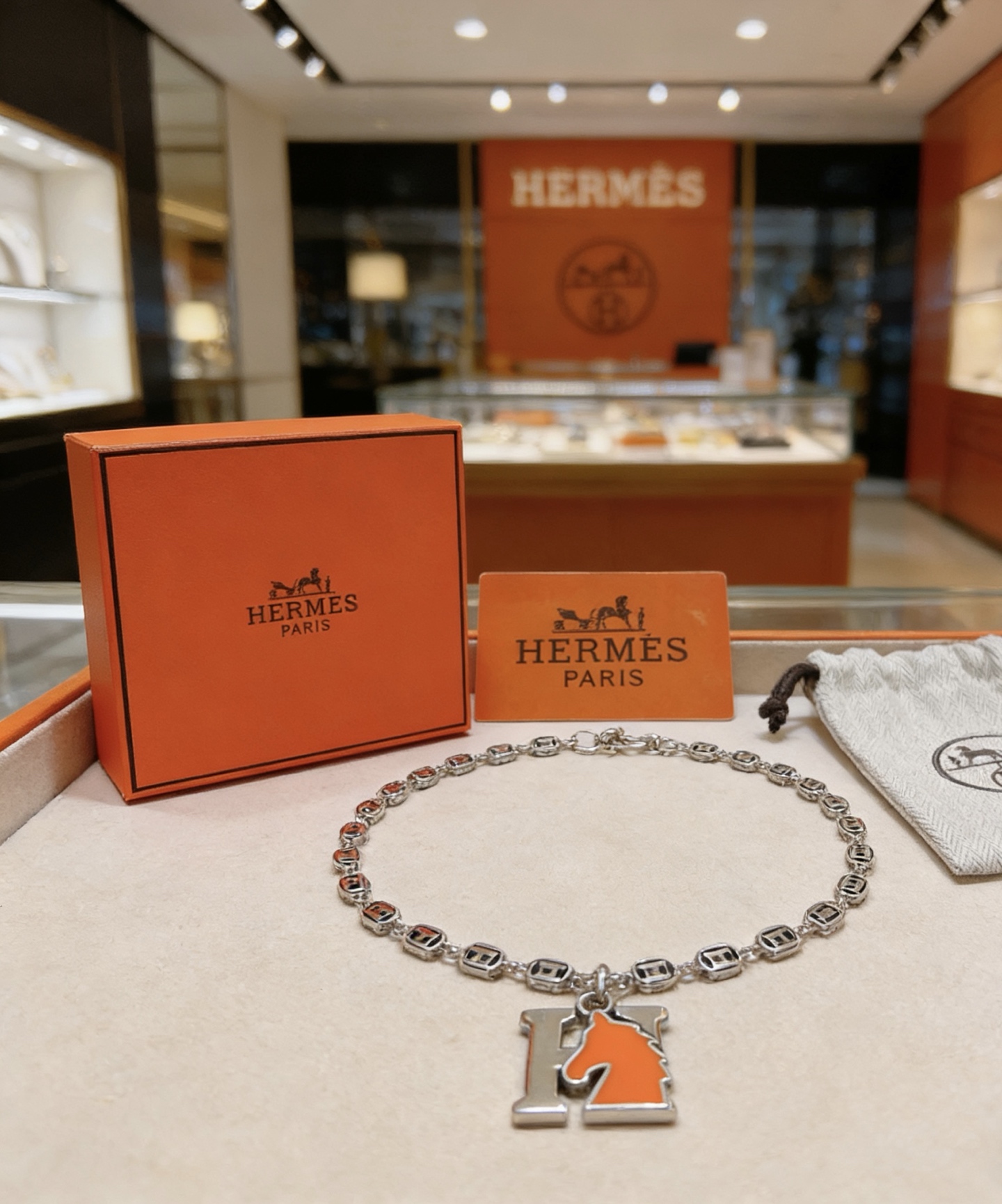 Collier pendentif Hermes Cheval H Métal argenté et émail orange 45cm