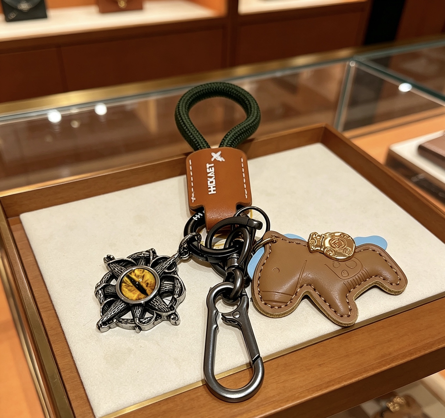 Hermes Rodeo Horse Charm Portachiavi Ciondolo in pelle marrone chiaro Cavo intrecciato verde scuro Hardware in canna di fucile Accento in metallo color oro Pietra gialla occhio di gatto Supporto azzurro 10 cm Lunghezza totale