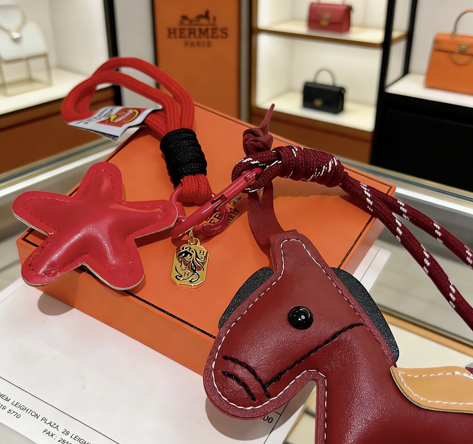 Hermes Rodeo Horse Star Bag Charm Keychain pendant Burgundy red leather with tan saddle black eye and tail accents gold-tone metal hardware red and burgundy woven lanyard 12cm total lanyard length