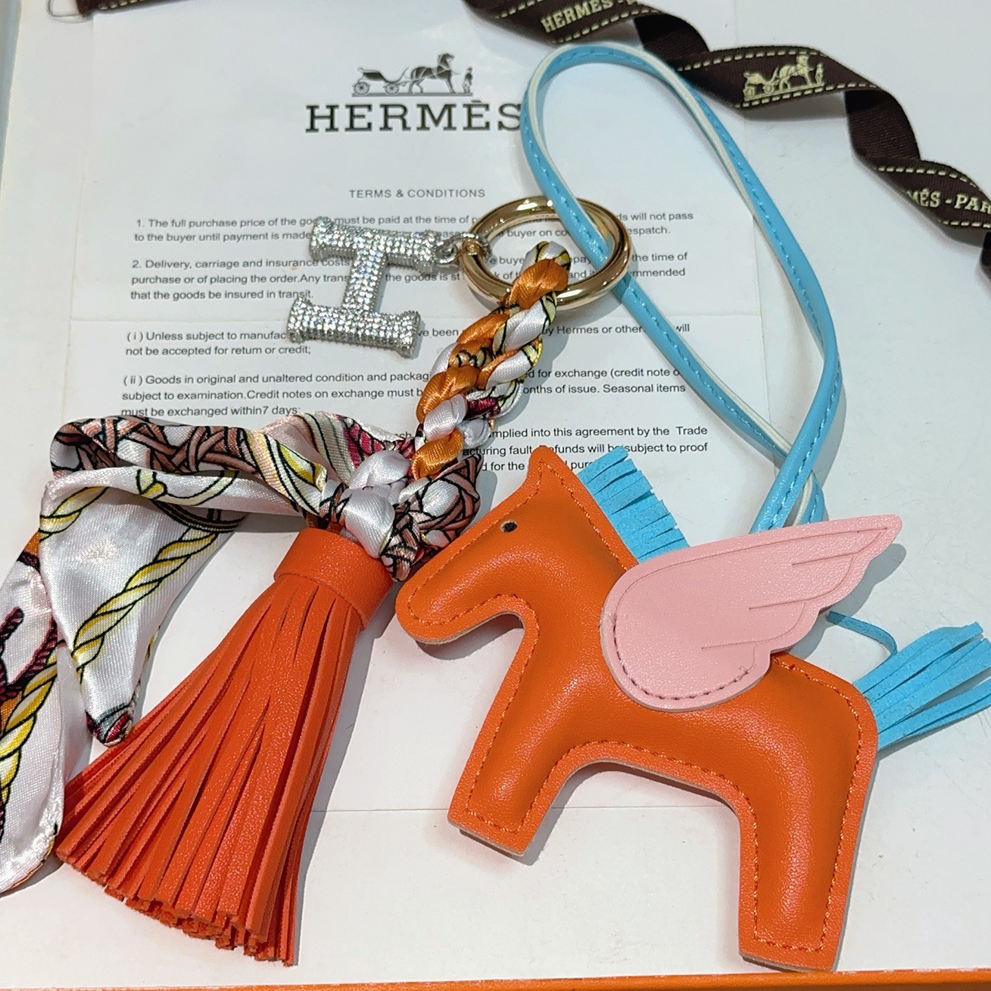 Hermes Rodeo Pegase pendant Orange lambskin with light blue lambskin mane tail pink lambskin wings gold-tone metal hardware clear crystal pave H charm multicolor printed silk twill tassel light blue leather strap 12cm