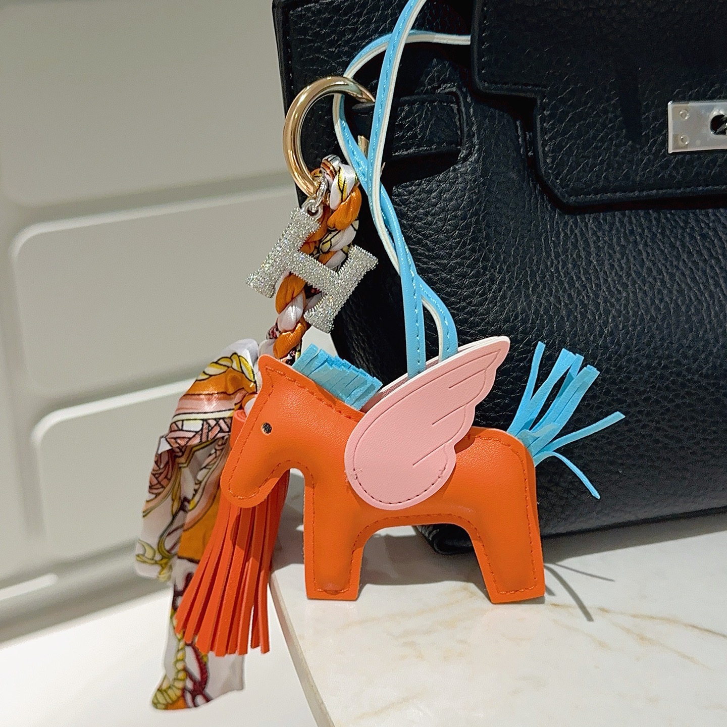 Hermes Rodeo Pegase pendant Orange lambskin with light blue lambskin mane tail pink lambskin wings gold-tone metal hardware clear crystal pave H charm multicolor printed silk twill tassel light blue leather strap 12cm