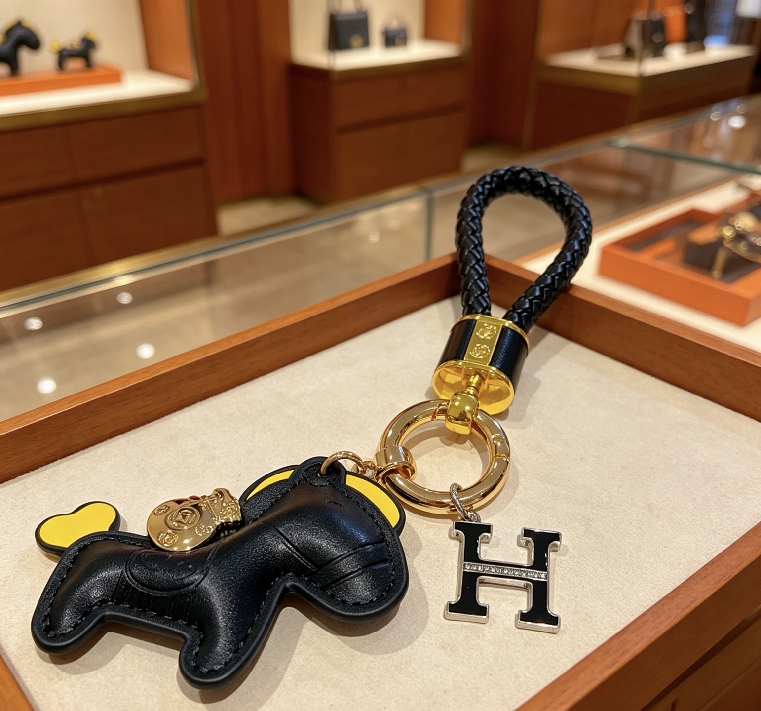 Hermes Rodeo Horse H Logo Braided Keychain pendant Black braided leather gold-tone metal hardware black leather horse charm with yellow accents black enamel H charm with clear crystal detailing 12cm total length