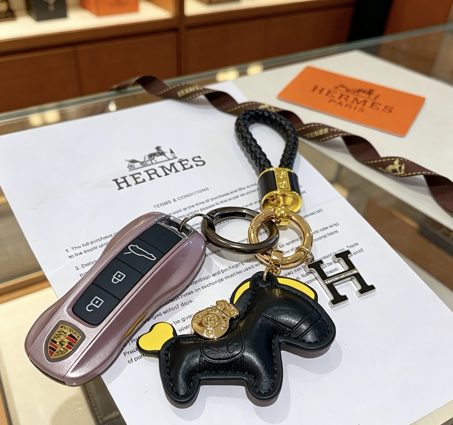 Hermes Rodeo Horse H Logo Braided Keychain pendant Black braided leather gold-tone metal hardware black leather horse charm with yellow accents black enamel H charm with clear crystal detailing 12cm total length