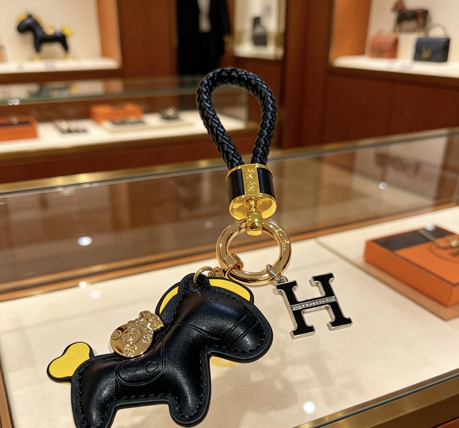 Hermes Rodeo Horse H Logo Braided Keychain pendant Black braided leather gold-tone metal hardware black leather horse charm with yellow accents black enamel H charm with clear crystal detailing 12cm total length