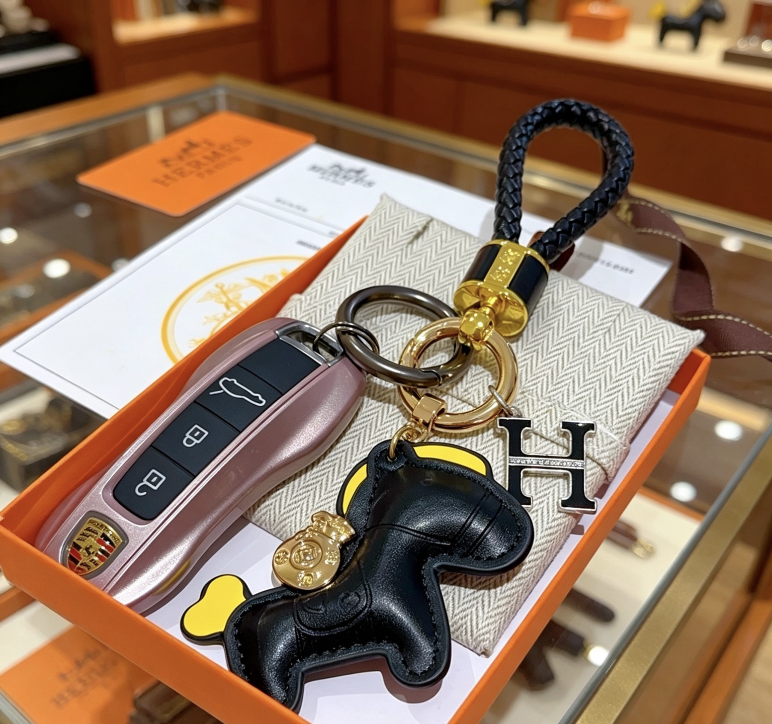 Hermes Rodeo Horse H Logo Braided Keychain pendant Black braided leather gold-tone metal hardware black leather horse charm with yellow accents black enamel H charm with clear crystal detailing 12cm total length