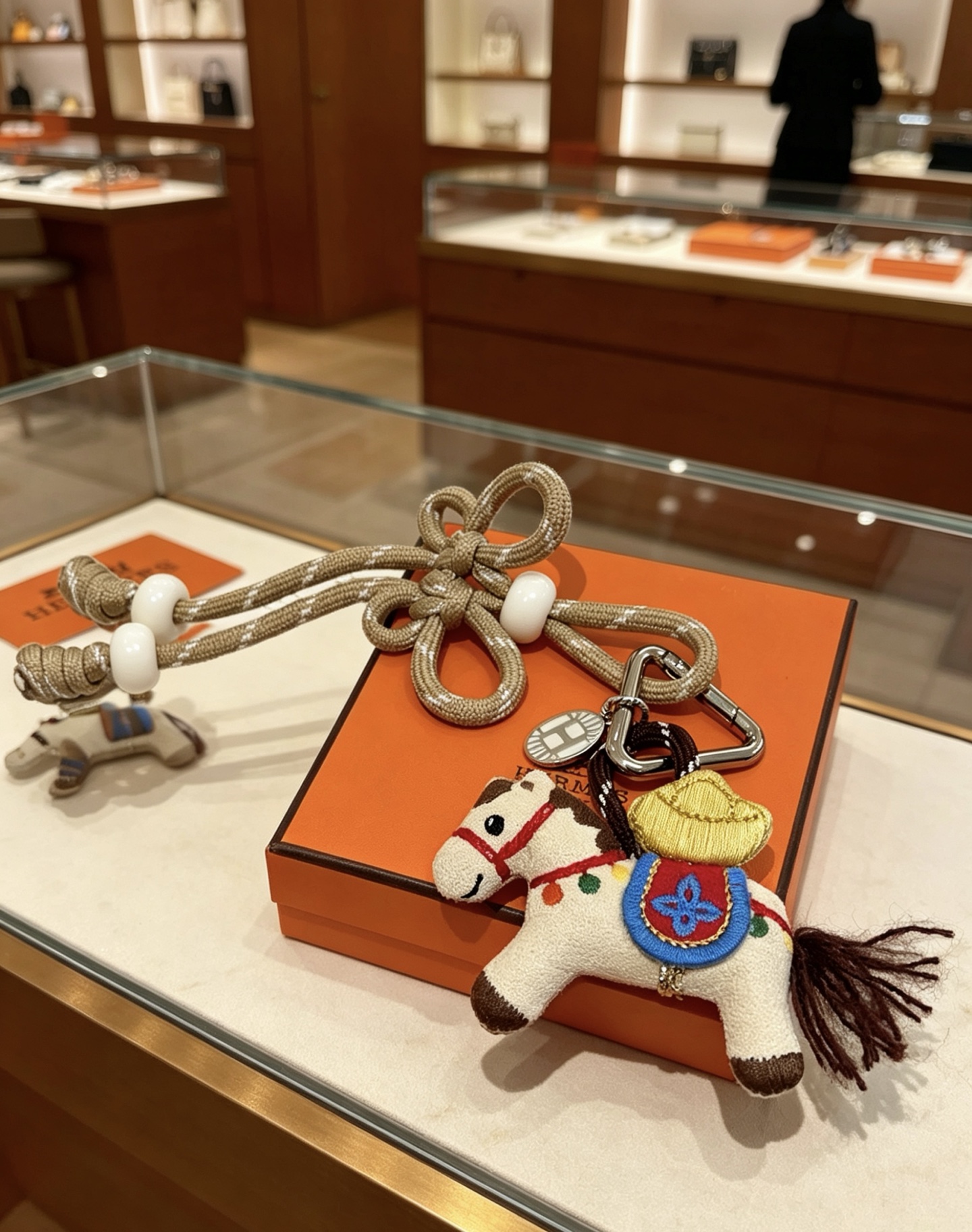 Hermes Rodeo Chinese Knot Horse Charm colgante de metal plateado paladio caballo de tela beige con bordado multicolor cordón tejido en oro champán con cuentas de resina blanca 12 cm de longitud total