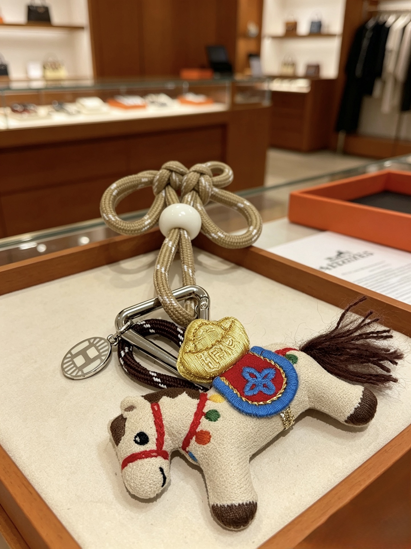 Hermes Rodeo Chinese Knot Horse Charm pendant palladium silver metal beige fabric horse with multicolor embroidery champagne gold woven cord with white resin beads 12cm total length