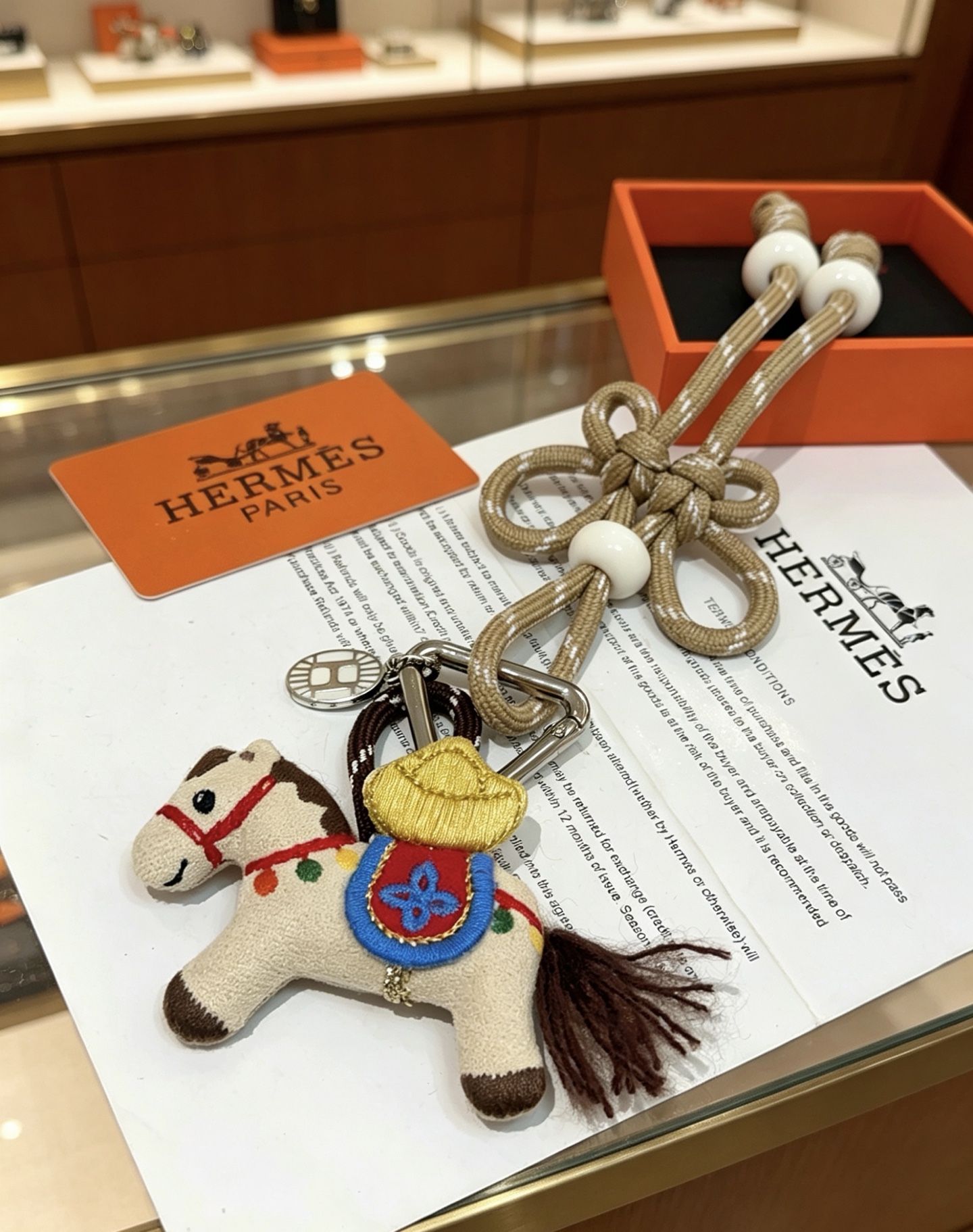 Hermes Rodeo Chinese Knot Horse Charm pendant palladium silver metal beige fabric horse with multicolor embroidery champagne gold woven cord with white resin beads 12cm total length