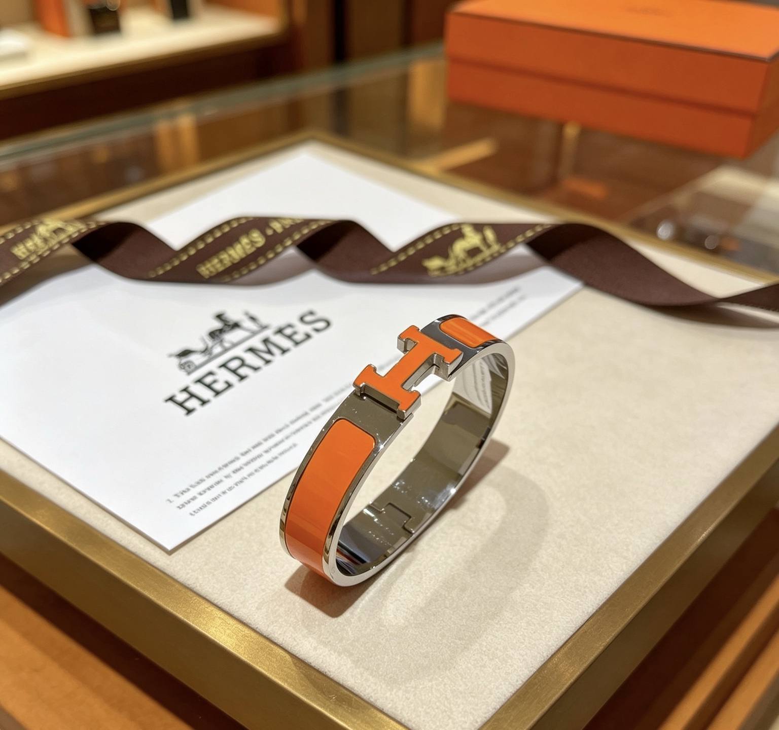 Pulsera Hermes Clic H metal plateado paladio esmalte naranja PM