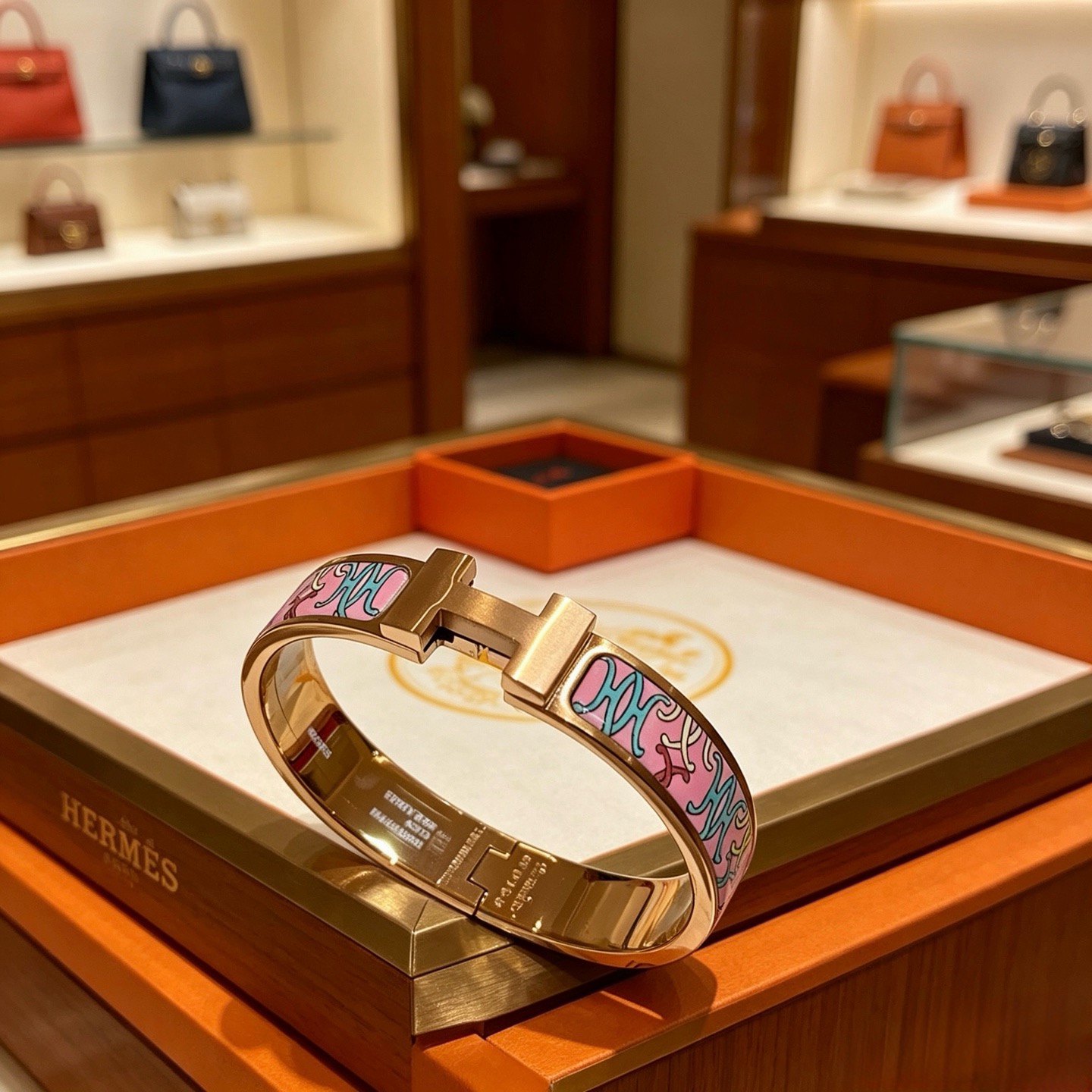 Bracelet Hermes Clic H en métal doré rose et émail rose à motifs décoratifs multicolores 17