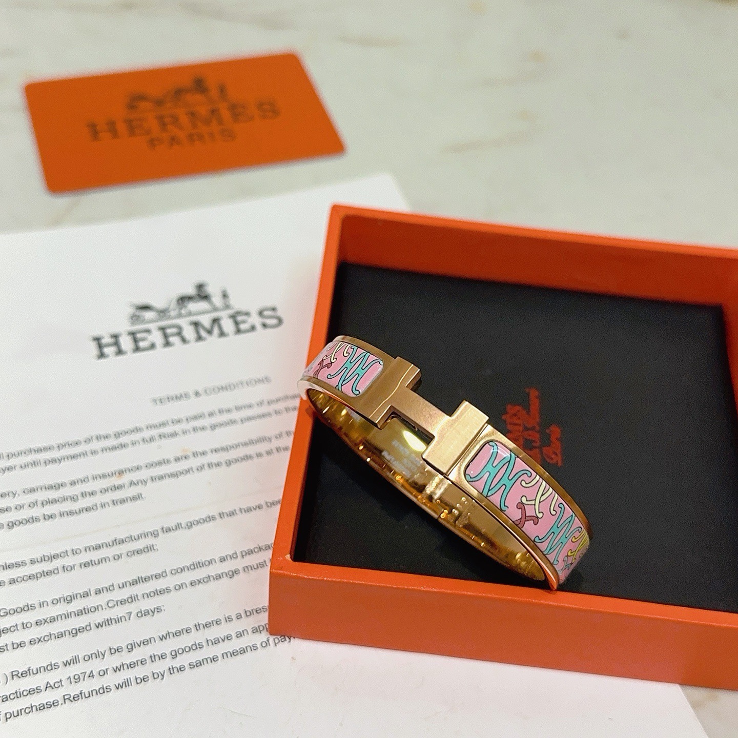 Bracelet Hermes Clic H en métal doré rose et émail rose à motifs décoratifs multicolores 17