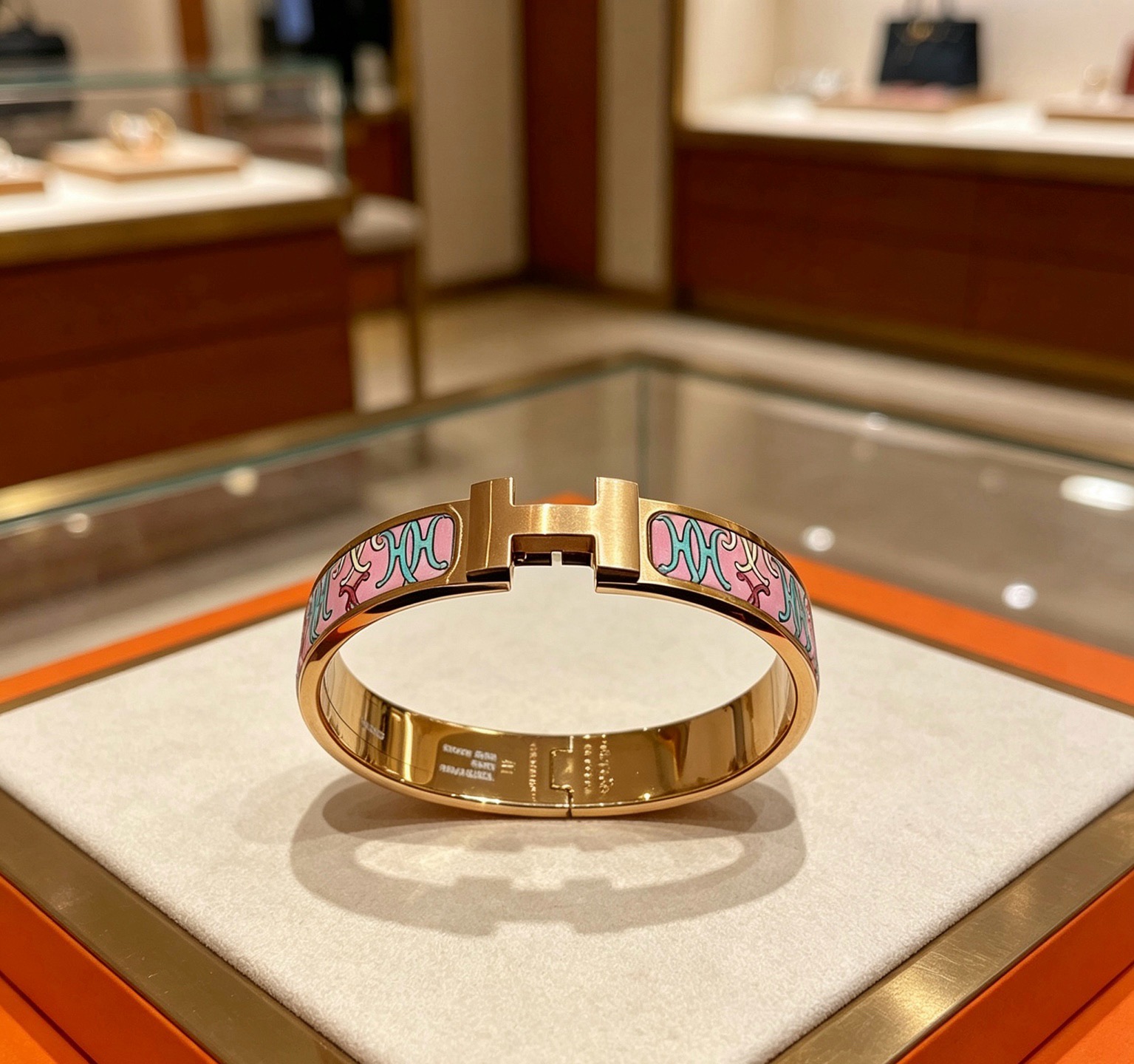Bracelet Hermes Clic H en métal doré rose et émail rose à motifs décoratifs multicolores 17