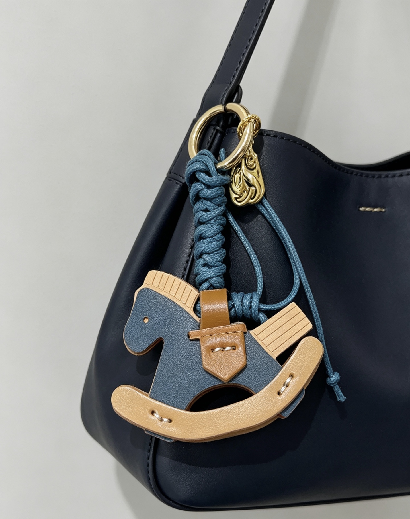 Ciondolo con ciondolo per borsa Hermes con cavallo a dondolo Cavo intrecciato in metallo color oro blu intenso marrone chiaro blu scuro e pelle beige chiaro lunghezza totale 12 cm