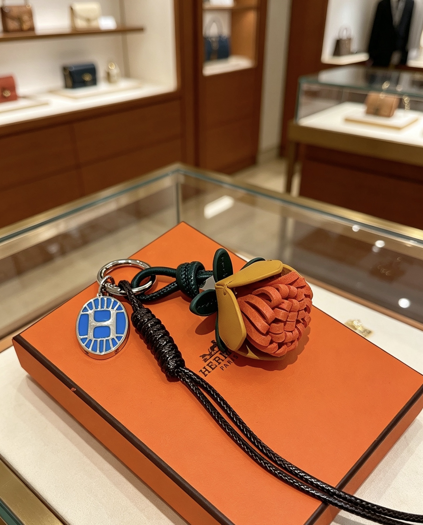 Hermes Protea Flower Charm Keychain pendant Silver-tone metal with blue enamel multi-tone leather orange mustard yellow dark green black braided cord brown wooden beads 12cm total lanyard length