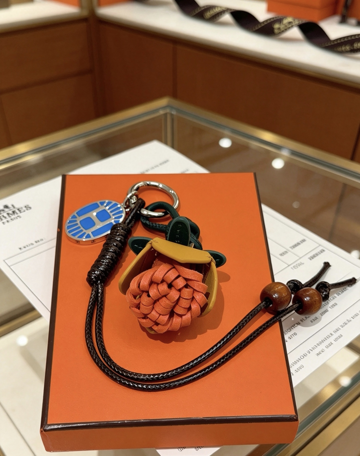 Hermes Protea Flower Charm Keychain pendant Silver-tone metal with blue enamel multi-tone leather orange mustard yellow dark green black braided cord brown wooden beads 12cm total lanyard length