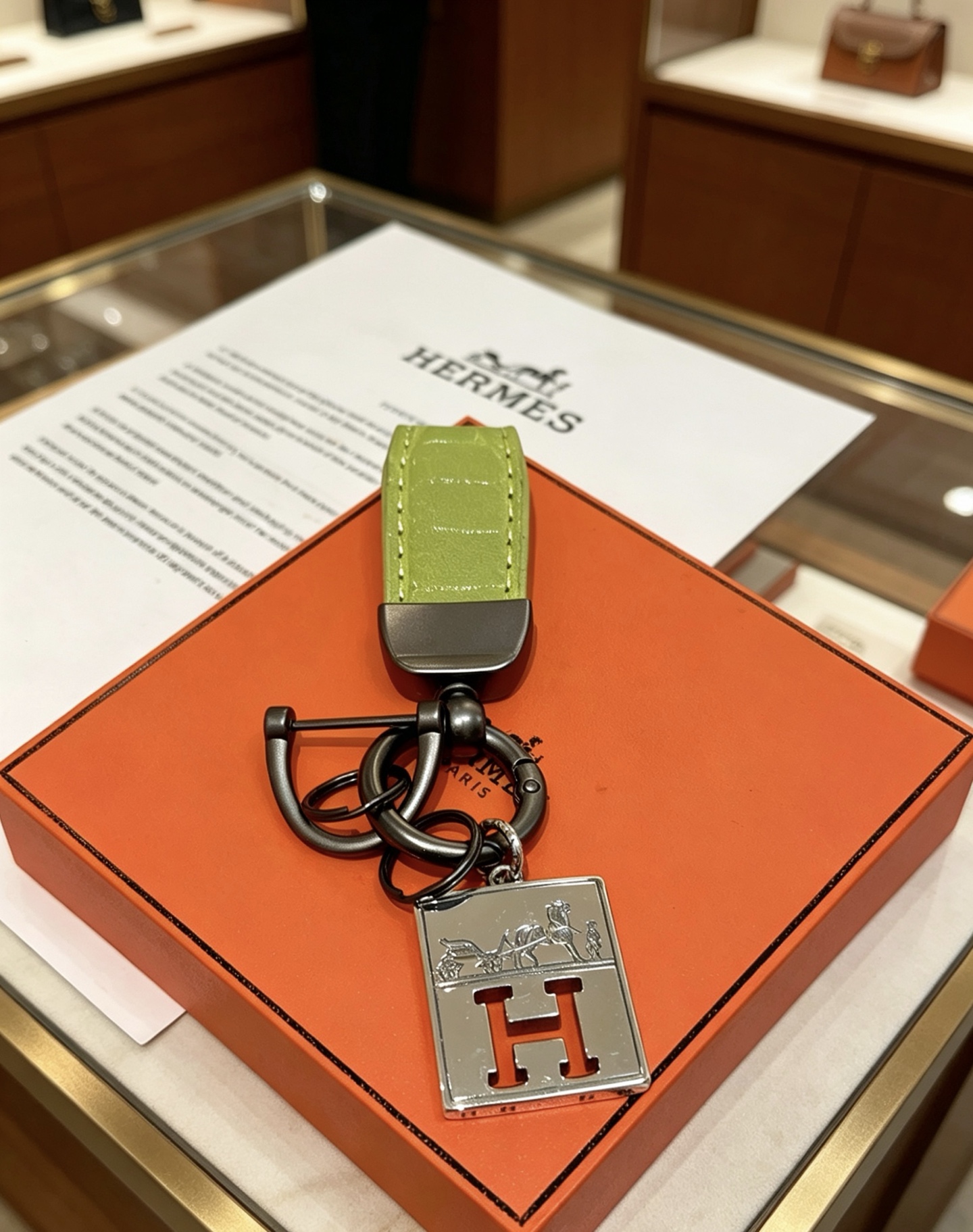 Ciondolo Hermes H Logo Caleche Key Metallo color argento canna di fucile con pelle di coccodrillo verde chartreuse goffrata, lunghezza totale 10 cm
