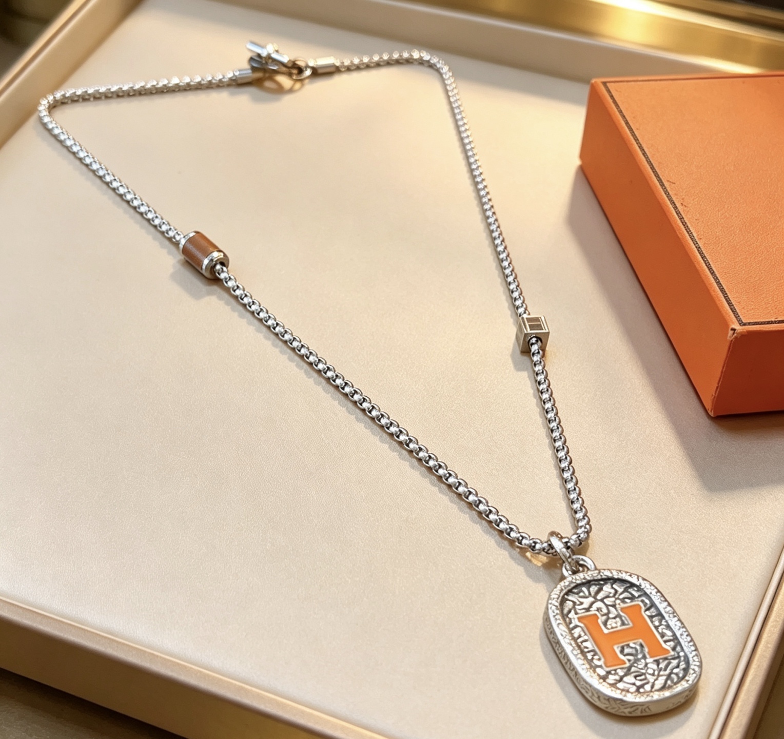 Hermes H Logo Oval Pendant Necklace necklace Silver-toned metal with orange enamel H detail brown leather accent bead 60cm