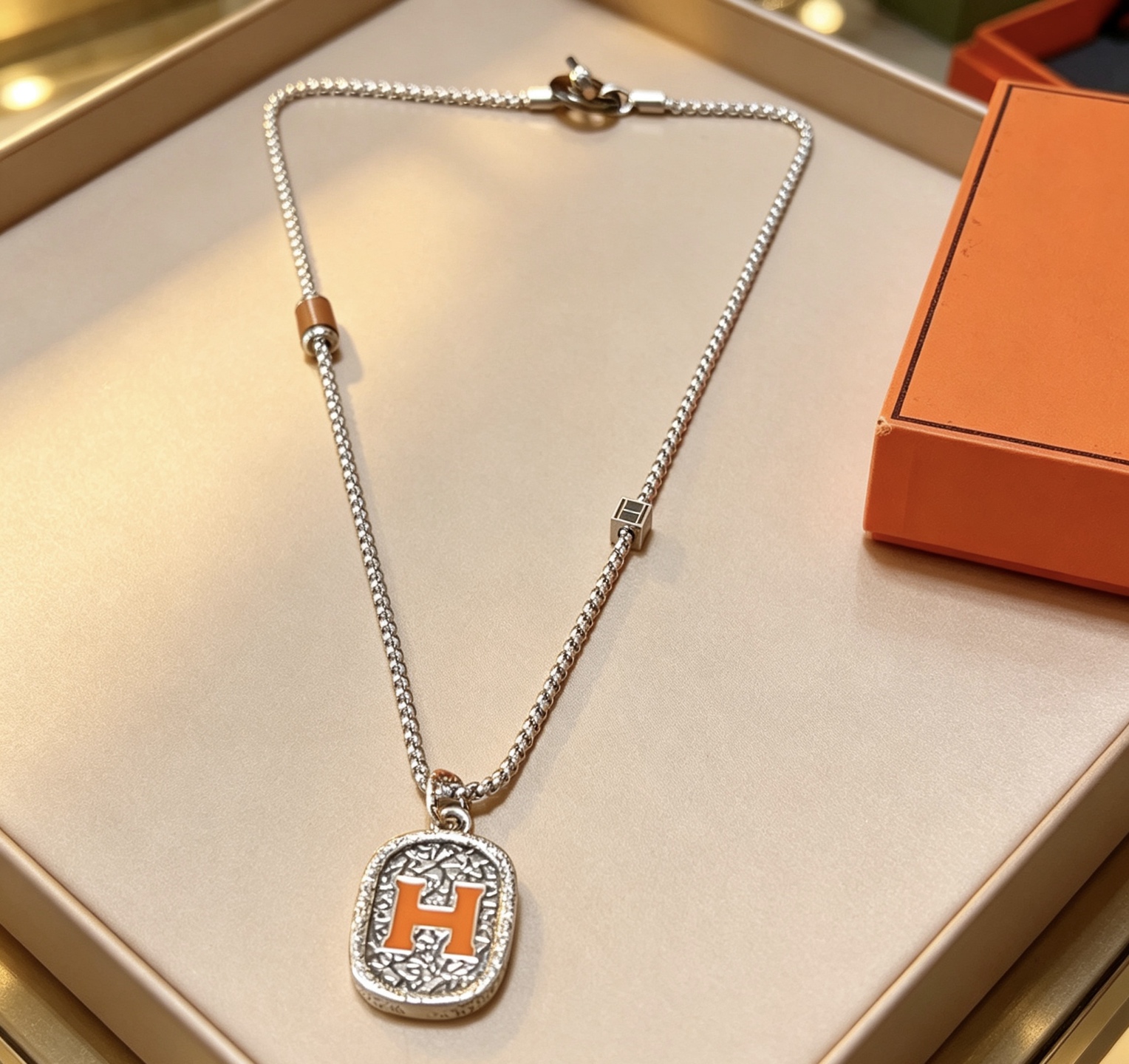 Hermes H Logo Oval Pendant Necklace necklace Silver-toned metal with orange enamel H detail brown leather accent bead 60cm
