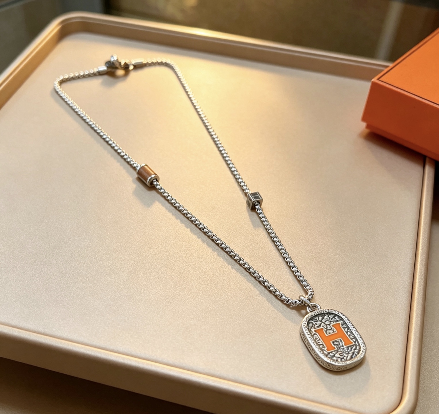 Hermes H Logo Oval Pendant Necklace necklace Silver-toned metal with orange enamel H detail brown leather accent bead 60cm