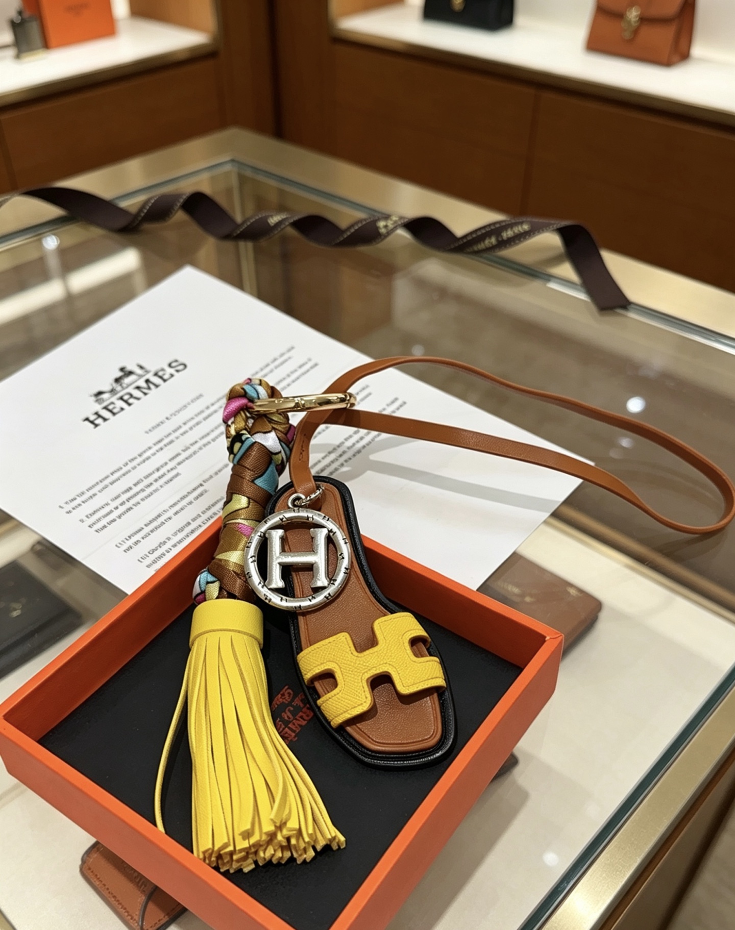 Hermes Oran Sandal Tassel Key Charm pendant Gold-tone and silver-tone metal yellow and brown leather multicolor silk black trim 18cm lanyard length