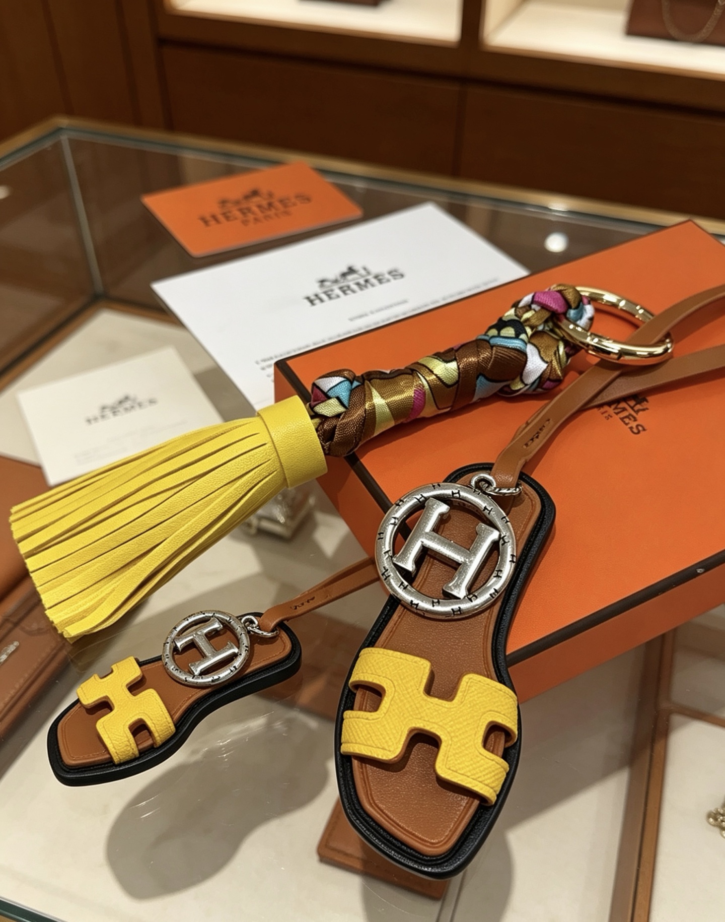 Hermes Oran Sandal Tassel Key Charm pendant Gold-tone and silver-tone metal yellow and brown leather multicolor silk black trim 18cm lanyard length