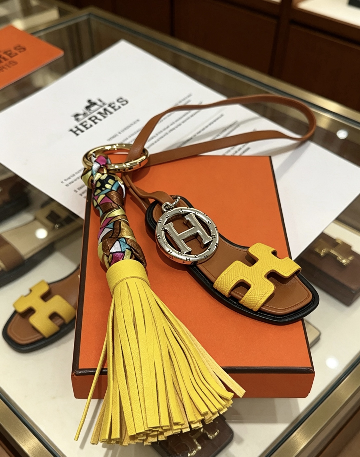 Hermes Oran Sandal Tassel Key Charm pendant Gold-tone and silver-tone metal yellow and brown leather multicolor silk black trim 18cm lanyard length
