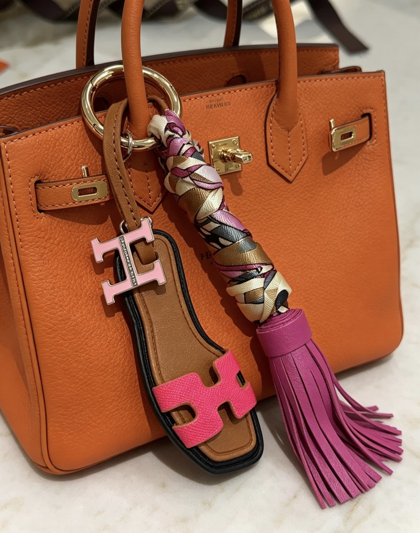 Hermes Oran Sandal Tassel Bag Charm Keychain pendant Gold-tone metal brown leather fuchsia pink leather multicolor silk twill light pink enamel H charm 12cm total length