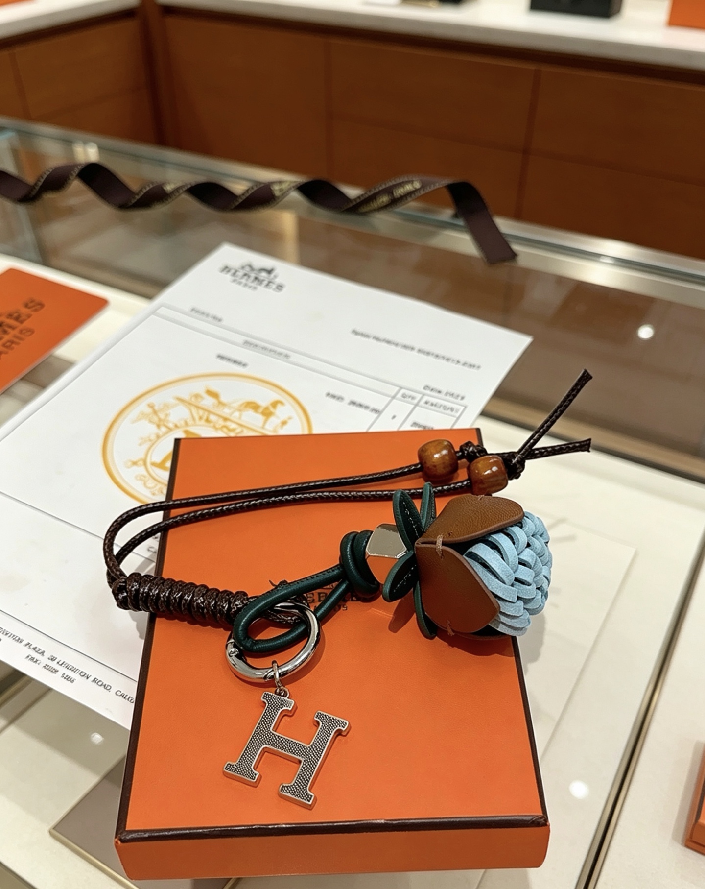 Hermes H Logo Leather Acorn Charm Keychain pendant Silver-tone metal dark brown braided leather dark green leather tan leather light blue woven leather brown wooden beads 18cm lanyard length
