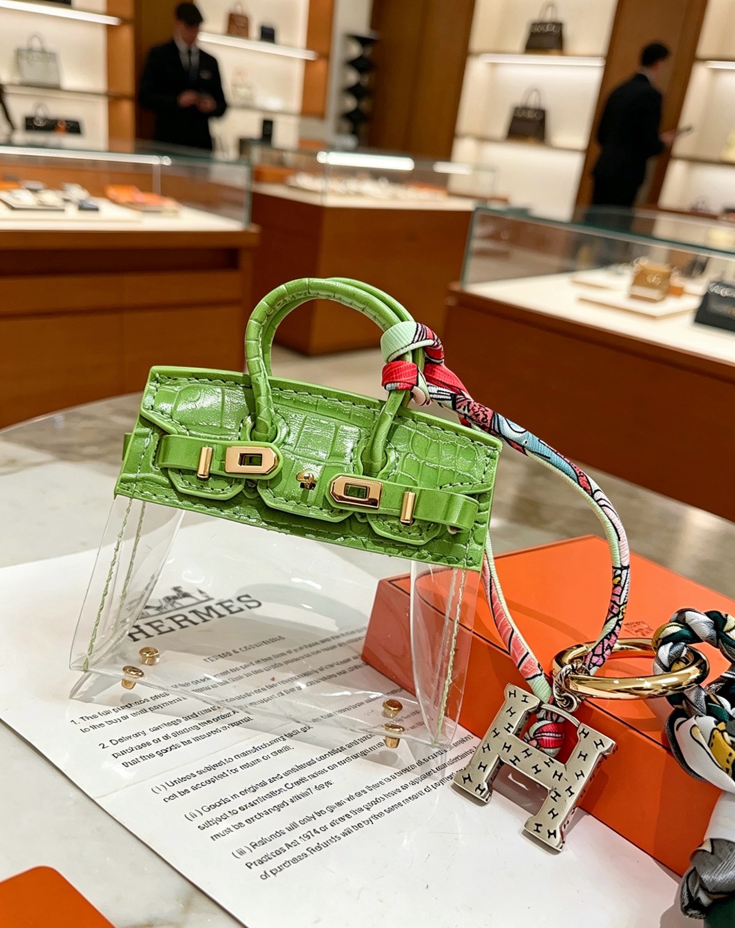 Hermes Birkin Bag Charm Keychain pendant Green crocodile-embossed leather gold-tone metal silver-tone metal multicolor printed silk dark green leather tassel clear vinyl 12cm total length