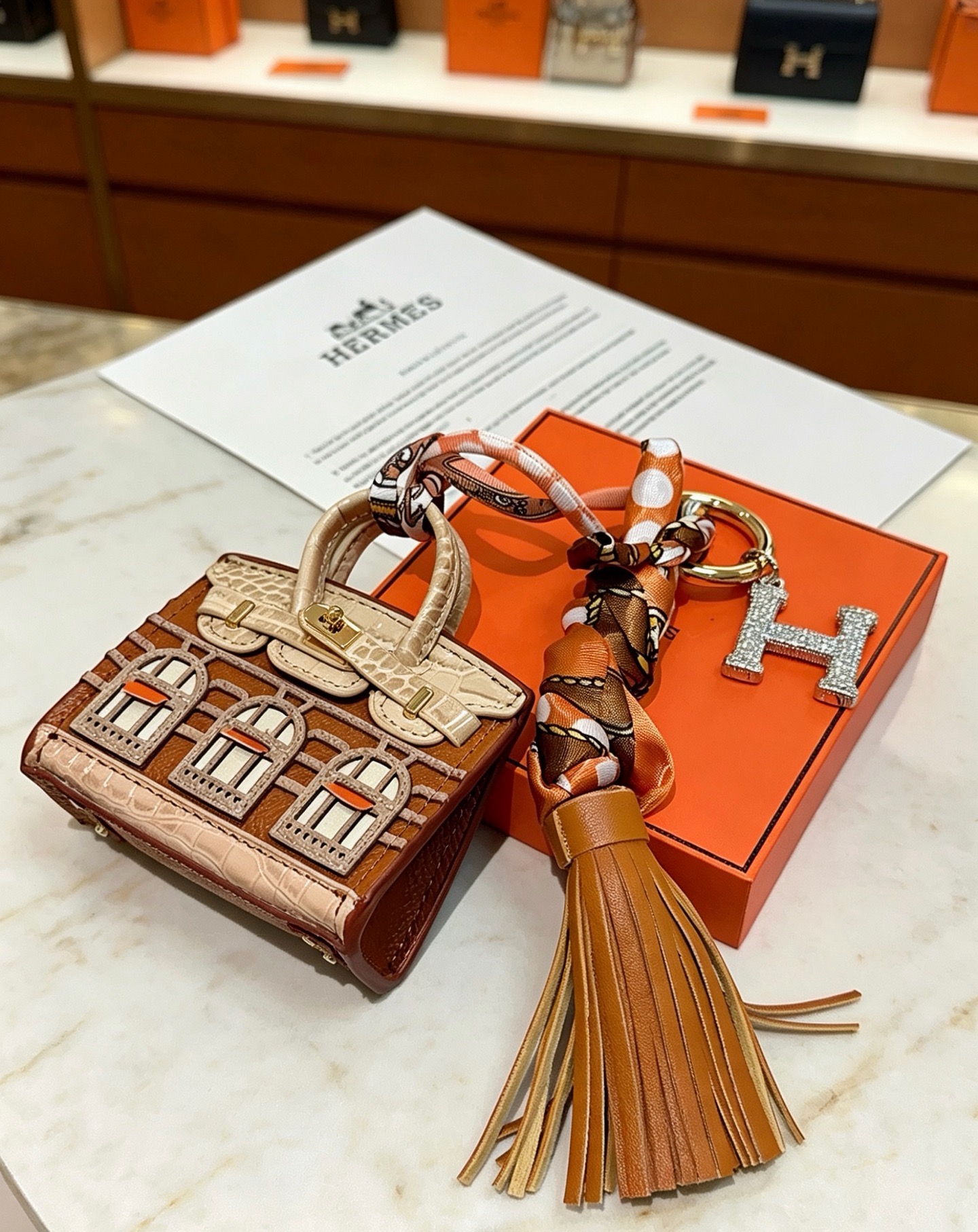 Hermes Birkin Faubourg Micro Bag Charm pendant Gold-tone metal brown beige orange leather orange brown beige silk clear crystal stones Total length 18cm
