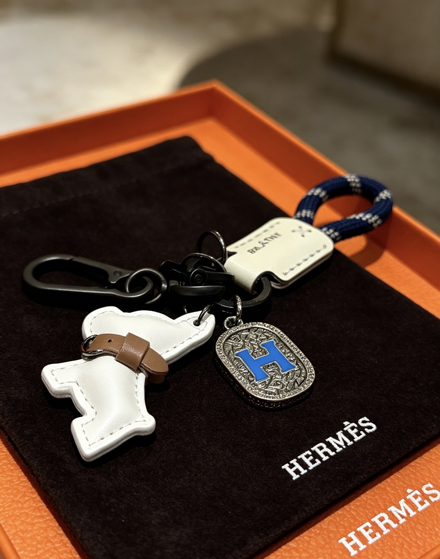 Hermes H Logo Puppy Charm Porte-clés pendentif Gunmetal matériel noir corde tressée bleu marine cuir blanc cassé cuir beige émail bleu Breloque H breloque gravée argentée 12 cm de longueur totale