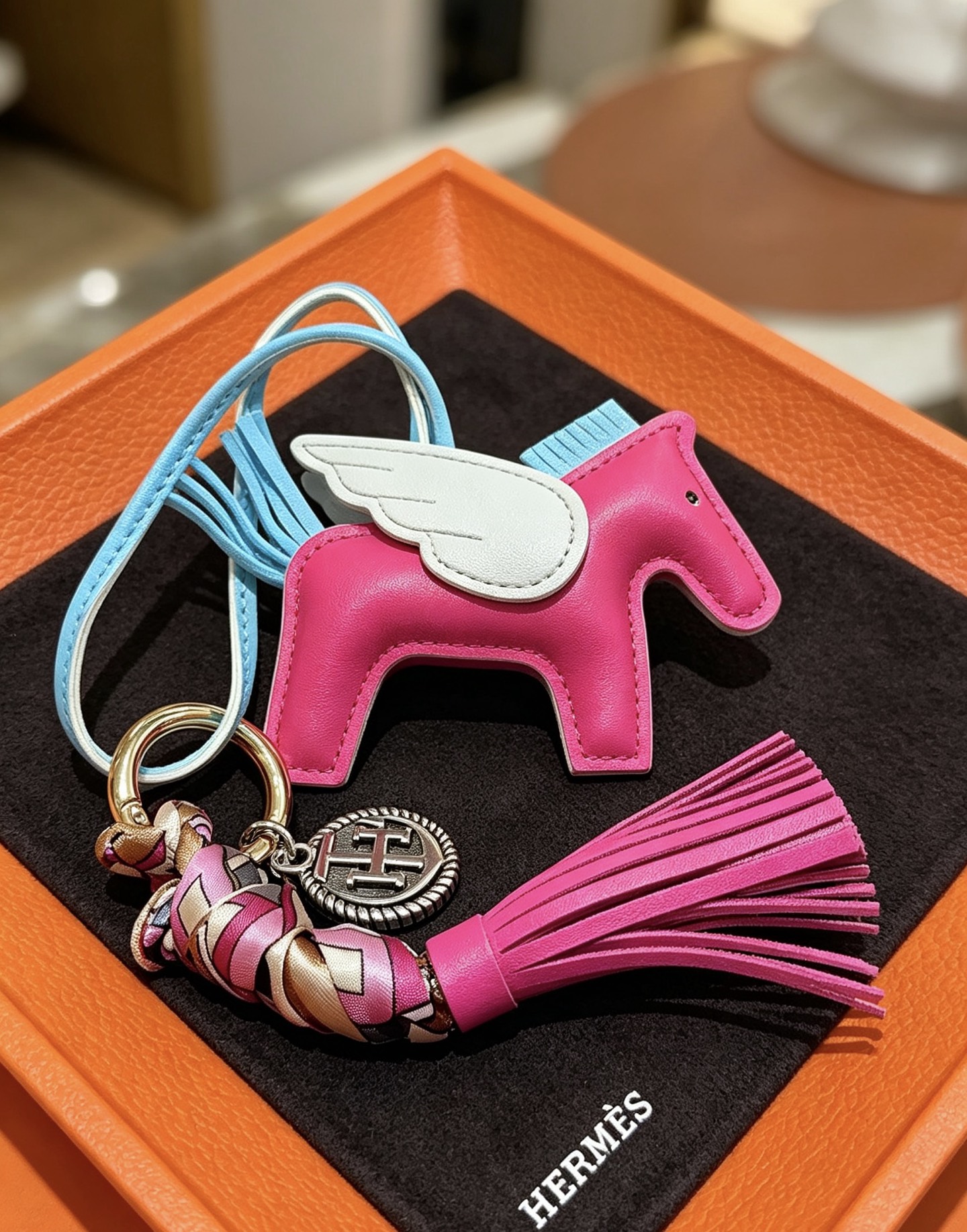 Pendentif à breloque de sac à pompon Hermes Rodeo Pegase Cuir blanc bleu clair rose vif avec détails en métal doré et tresse de soie multicolore Longueur totale de la breloque 12 cm