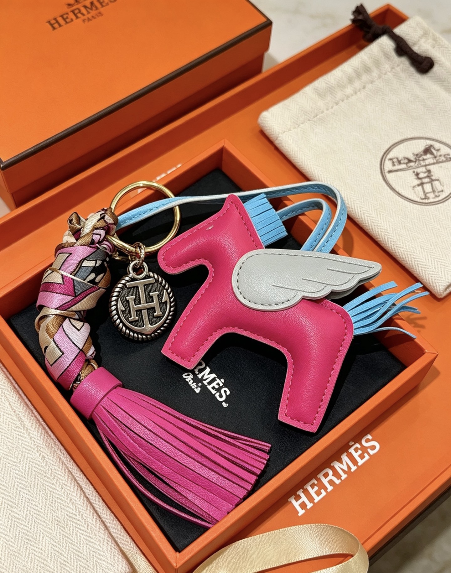 Pendentif à breloque de sac à pompon Hermes Rodeo Pegase Cuir blanc bleu clair rose vif avec détails en métal doré et tresse de soie multicolore Longueur totale de la breloque 12 cm