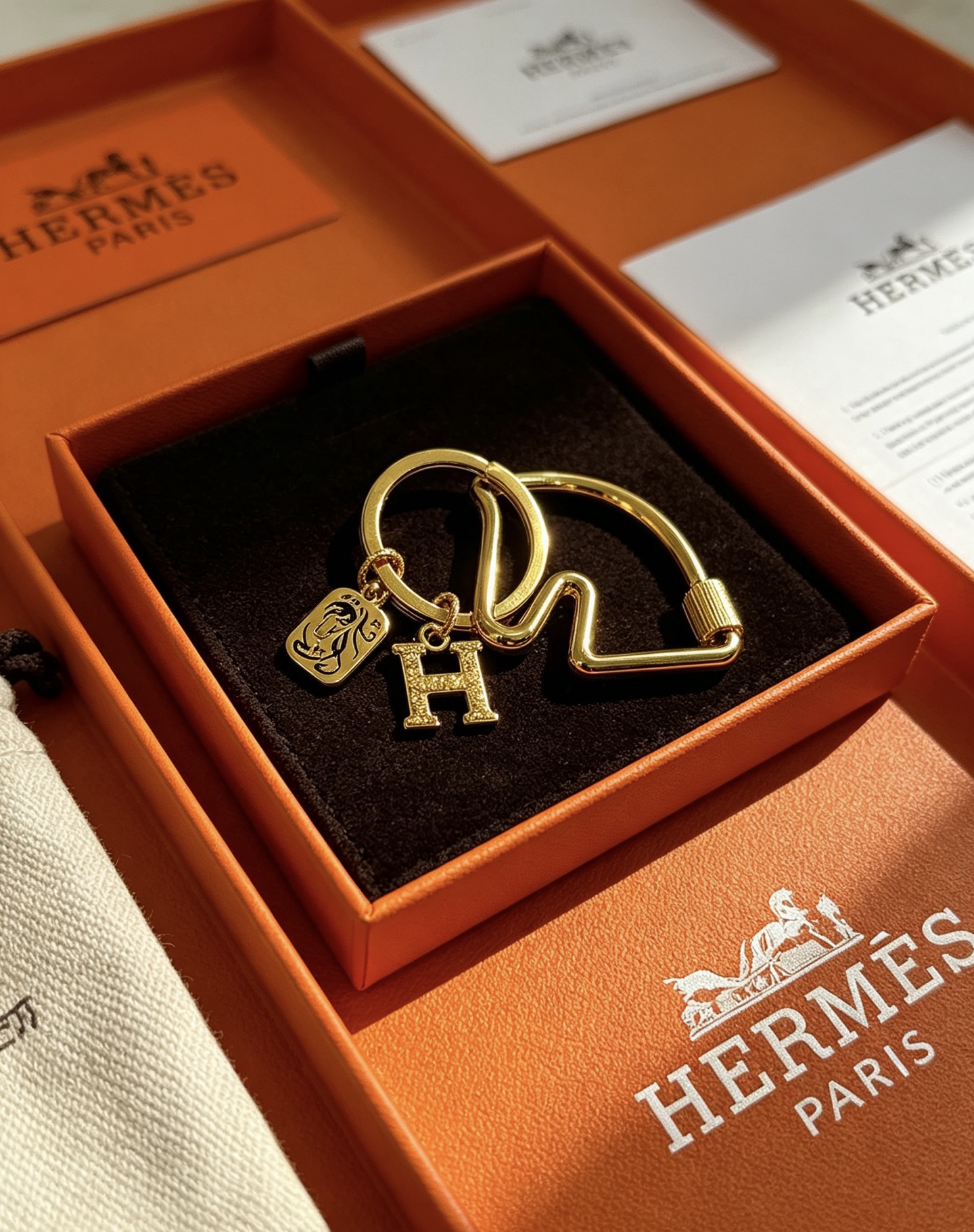 Ciondolo Hermes Olympia H Portachiavi in metallo color oro con ciondolo H in cristallo trasparente e ciondolo con motivo cavallo in smalto nero, diametro dell'anello di 3,5 cm