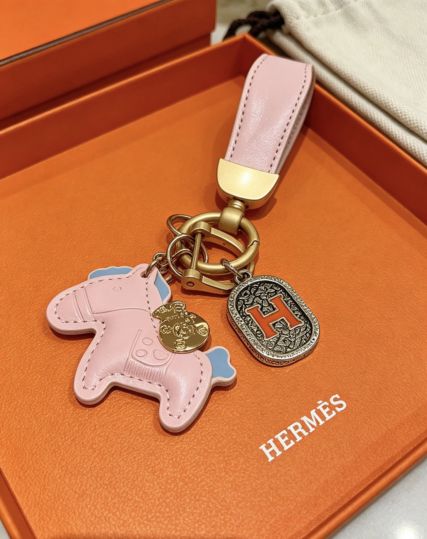Ciondolo Hermes Rodeo Horse H Logo Key Charm Pelle rosa con accenti azzurri color oro e metallo argentato antico dettaglio H smaltato arancione 10 cm di lunghezza totale