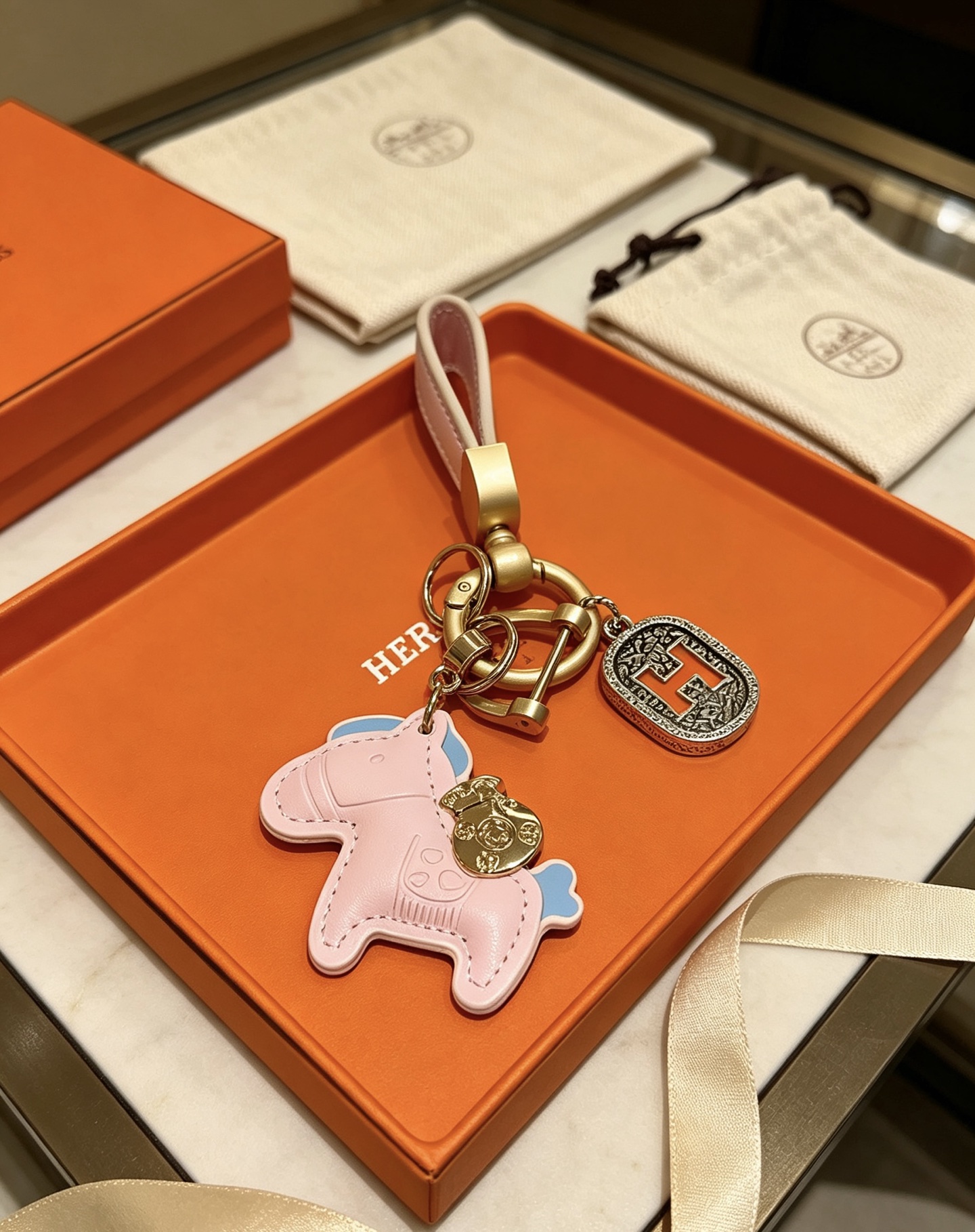 Ciondolo Hermes Rodeo Horse H Logo Key Charm Pelle rosa con accenti azzurri color oro e metallo argentato antico dettaglio H smaltato arancione 10 cm di lunghezza totale