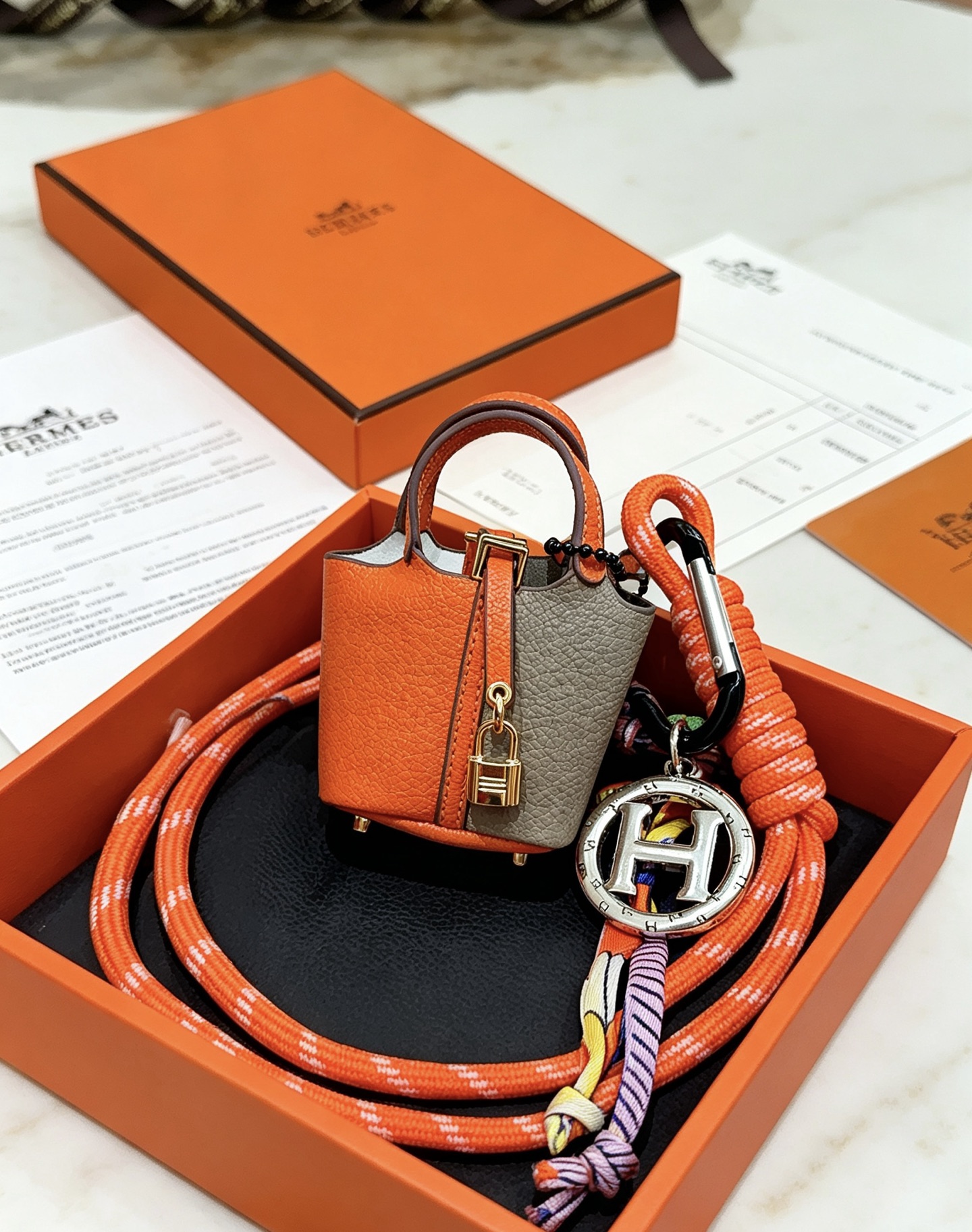 Hermes Mini Picotin Lock Bag Ciondolo con ciondolo Pelle arancione e grigia Hardware in metallo color oro Ciondolo con logo H color argento Accenti di cavo di seta multicolore 80 cm
