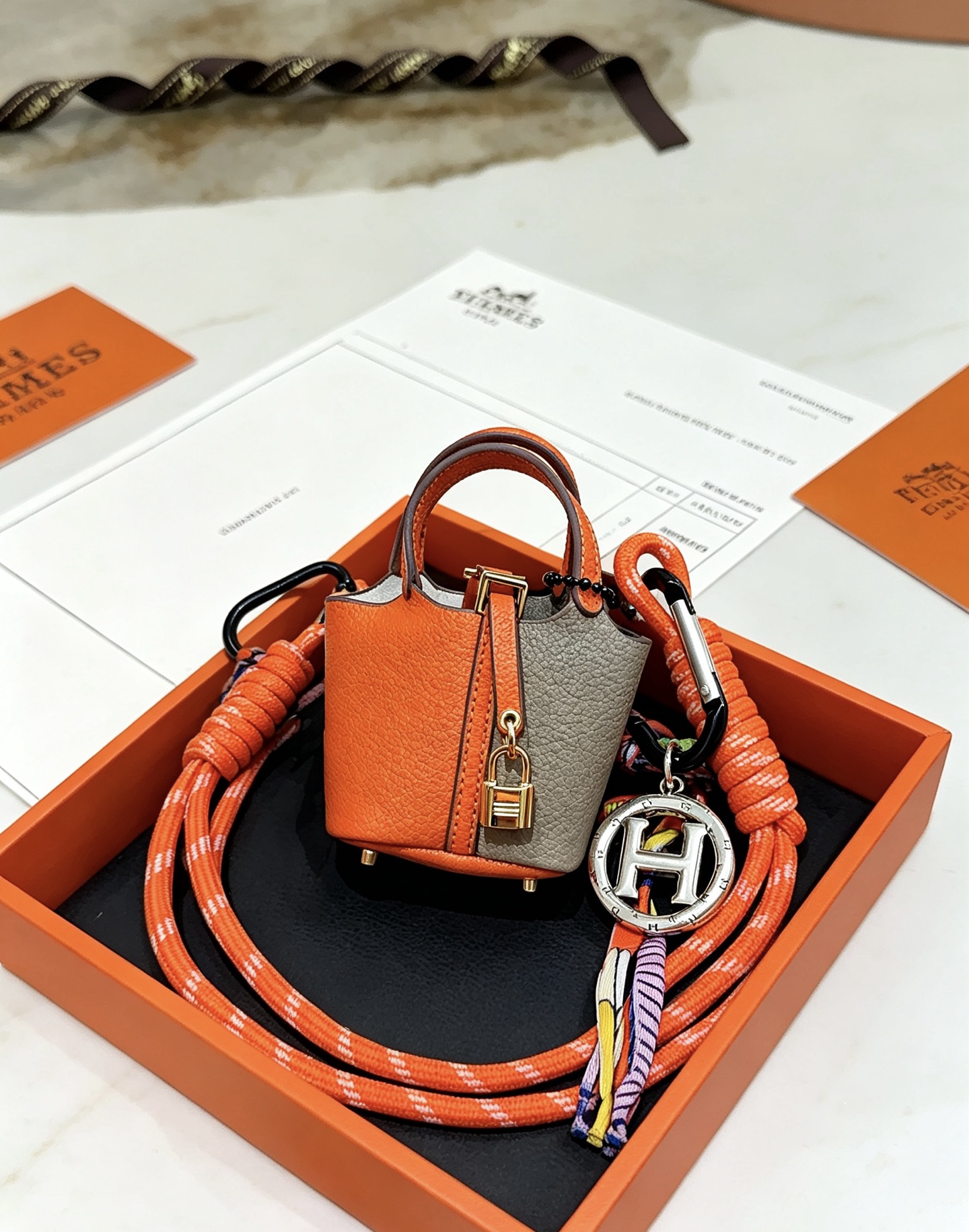 Hermes Mini Picotin Lock Bag Charm pendant Orange and gray leather gold-tone metal hardware silver-tone H logo charm multicolor silk cord accents 80cm