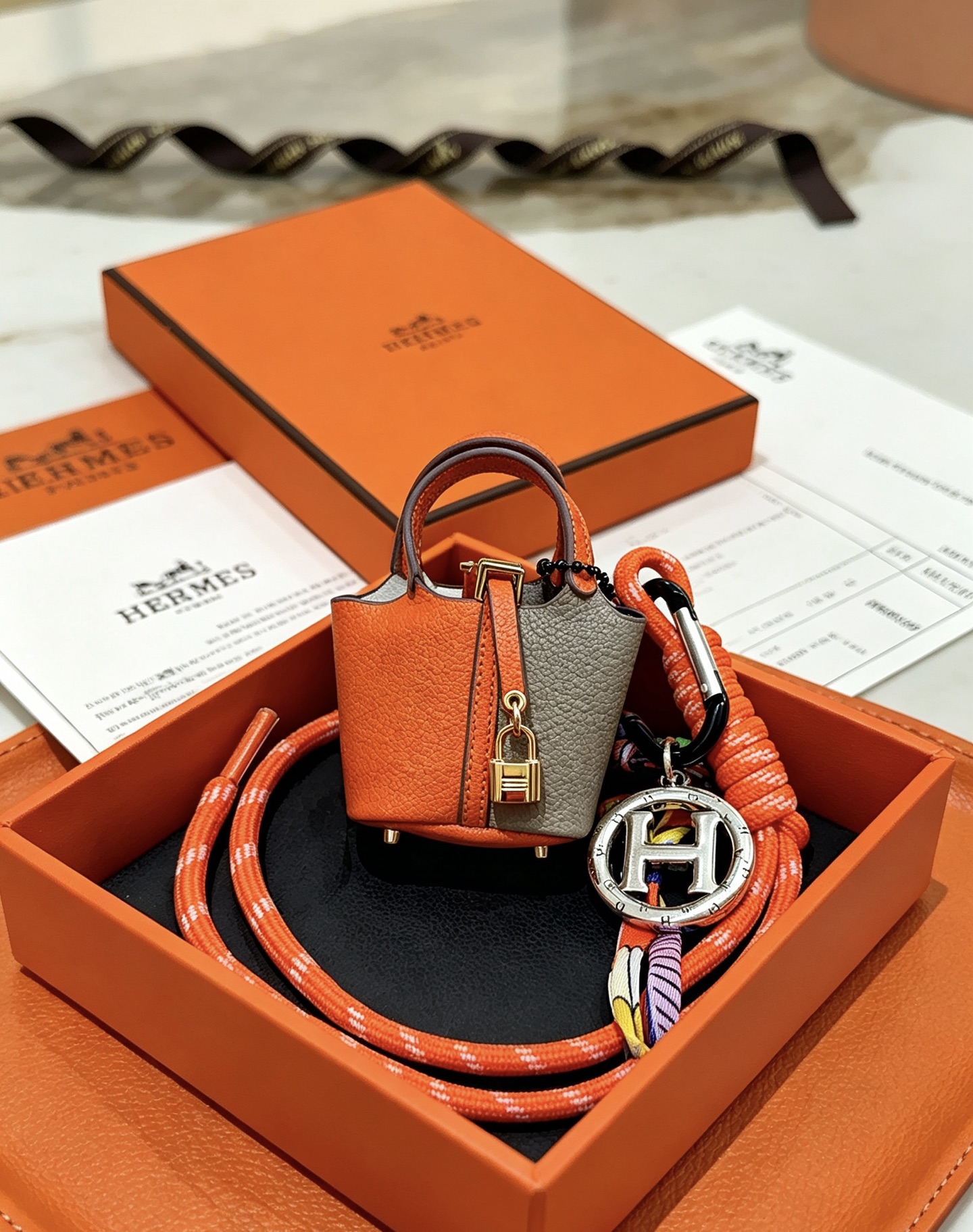 Hermes Mini Picotin Lock Bag Charm pendant Orange and gray leather gold-tone metal hardware silver-tone H logo charm multicolor silk cord accents 80cm