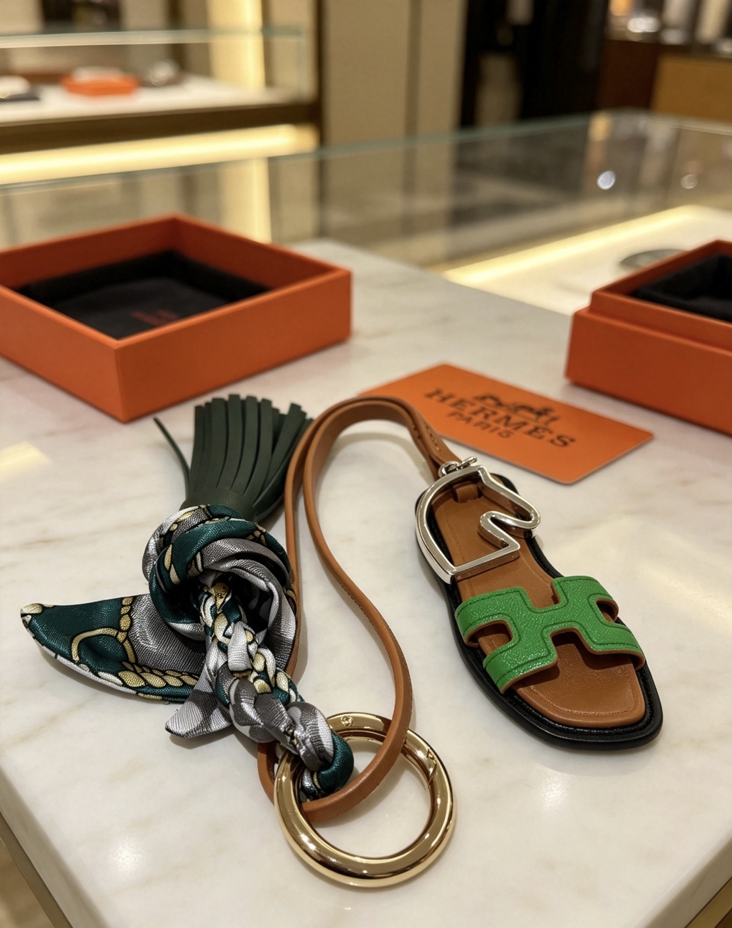 Hermes Oran Sandal Tassel Silk Twilly Bag Charm Keychain pendant Gold-tone and silver-tone metal brown leather dark green leather tassel green Epsom leather H detail multicolor gray-green-gold silk twilly 17cm strap length