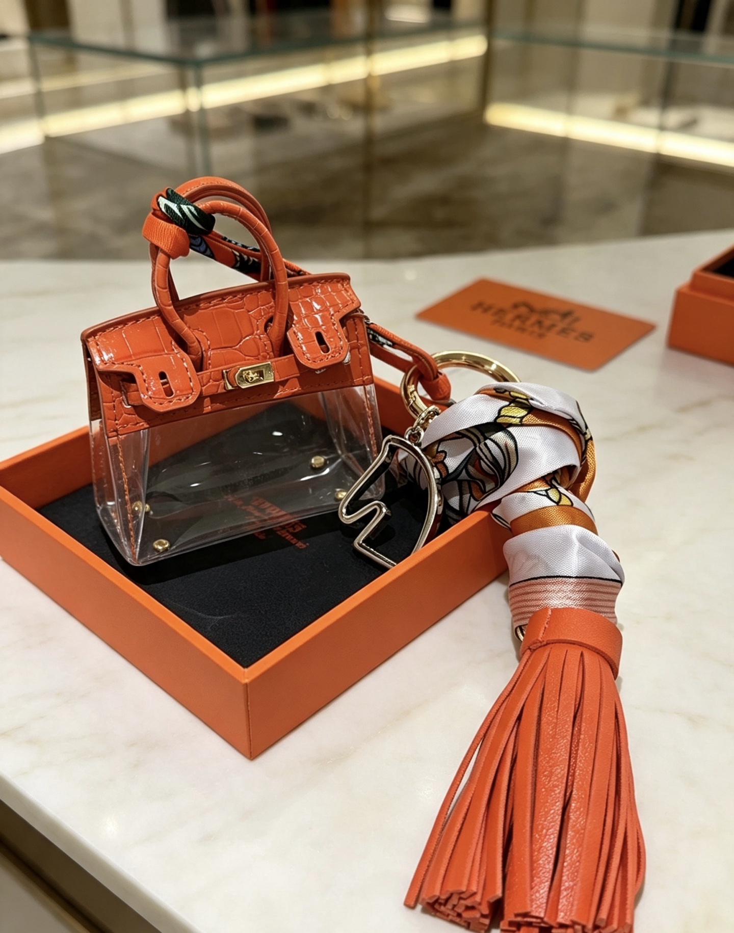 Borsa Hermes Mini Birkin Nappa Ciondolo ciondolo Pelle arancione goffrata coccodrillo PVC trasparente metallo color oro nappa in pelle arancione seta stampata multicolore Lunghezza totale 12 cm
