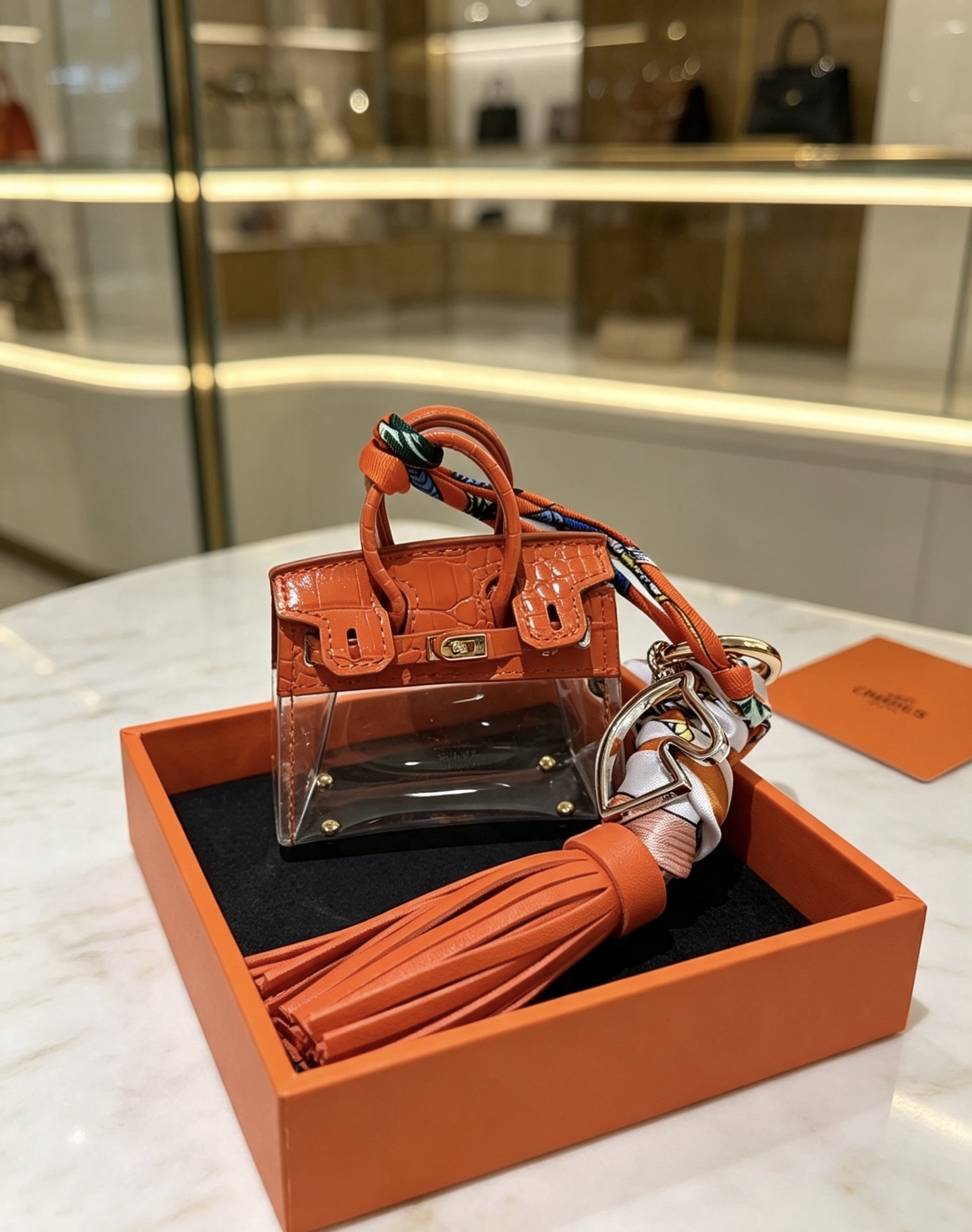 Borsa Hermes Mini Birkin Nappa Ciondolo ciondolo Pelle arancione goffrata coccodrillo PVC trasparente metallo color oro nappa in pelle arancione seta stampata multicolore Lunghezza totale 12 cm