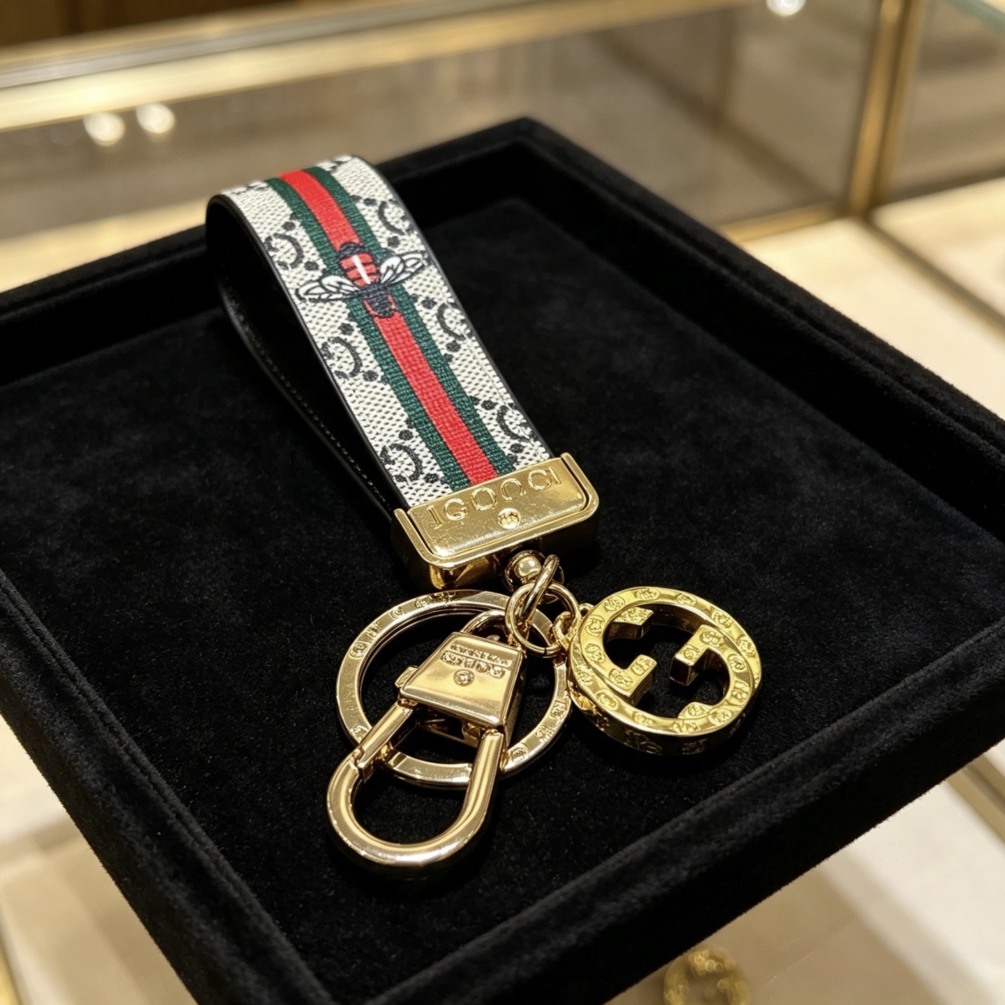 Gucci Anger Forest Bee Web GG Keychain pendant Gold-tone metal beige GG Supreme canvas with red and green web stripes brown leather trim multicolor bee embroidery 10cm strap length